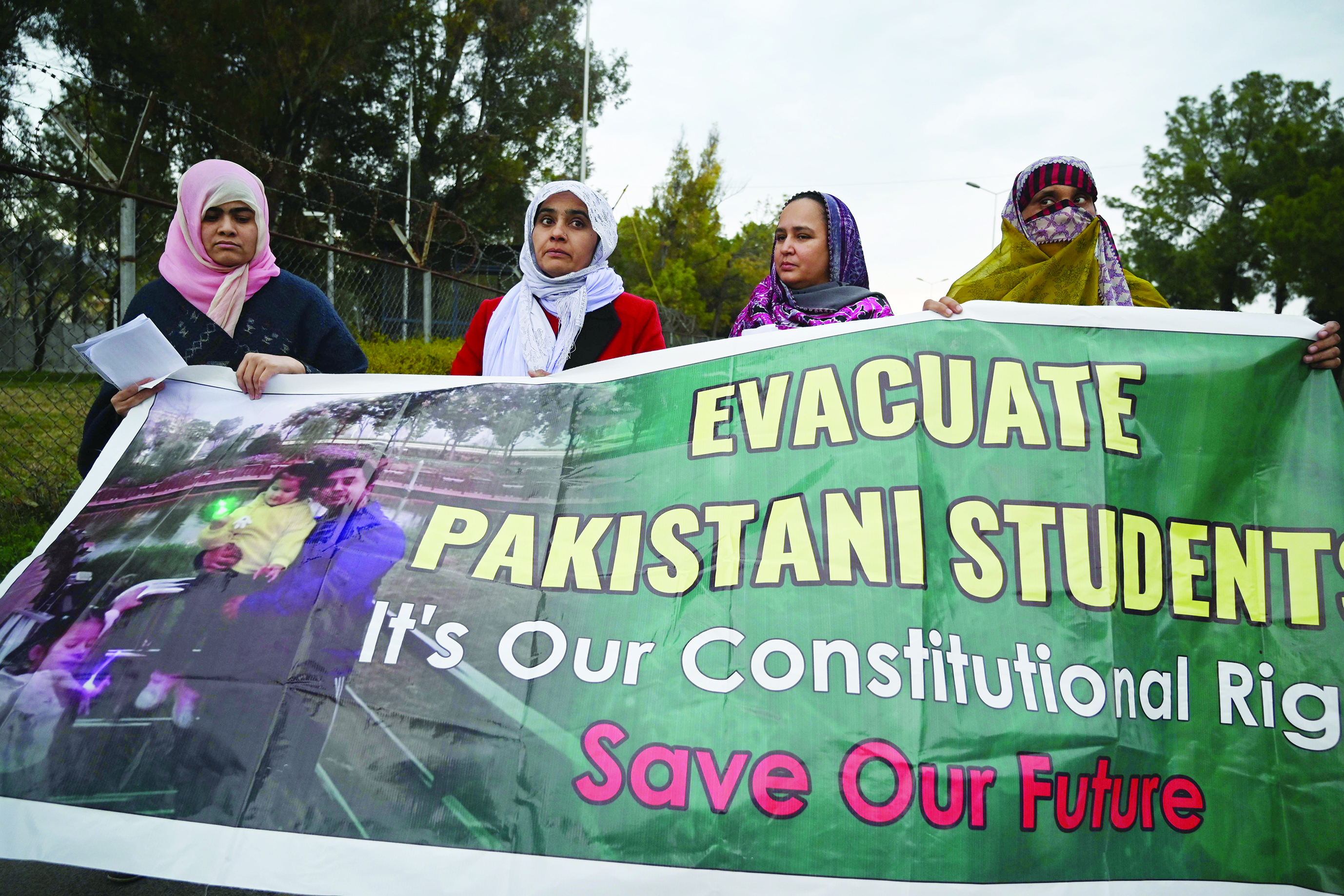 Parents and relatives of Pakistani students in the Chinese city of Wuhan, where the outbreak of the COVID-19 coronavirus began, hold placards during a protest to demand Pakistan's government the evacuation of their loved ones in Islamabad on February 19, 2020. - The death toll from China's new coronavirus epidemic jumped past 2,000 on February 19 after 136 more people died, with the number of new cases falling for a second straight day, according to the National Health Commission. (Photo by Aamir QURESHI / AFP)