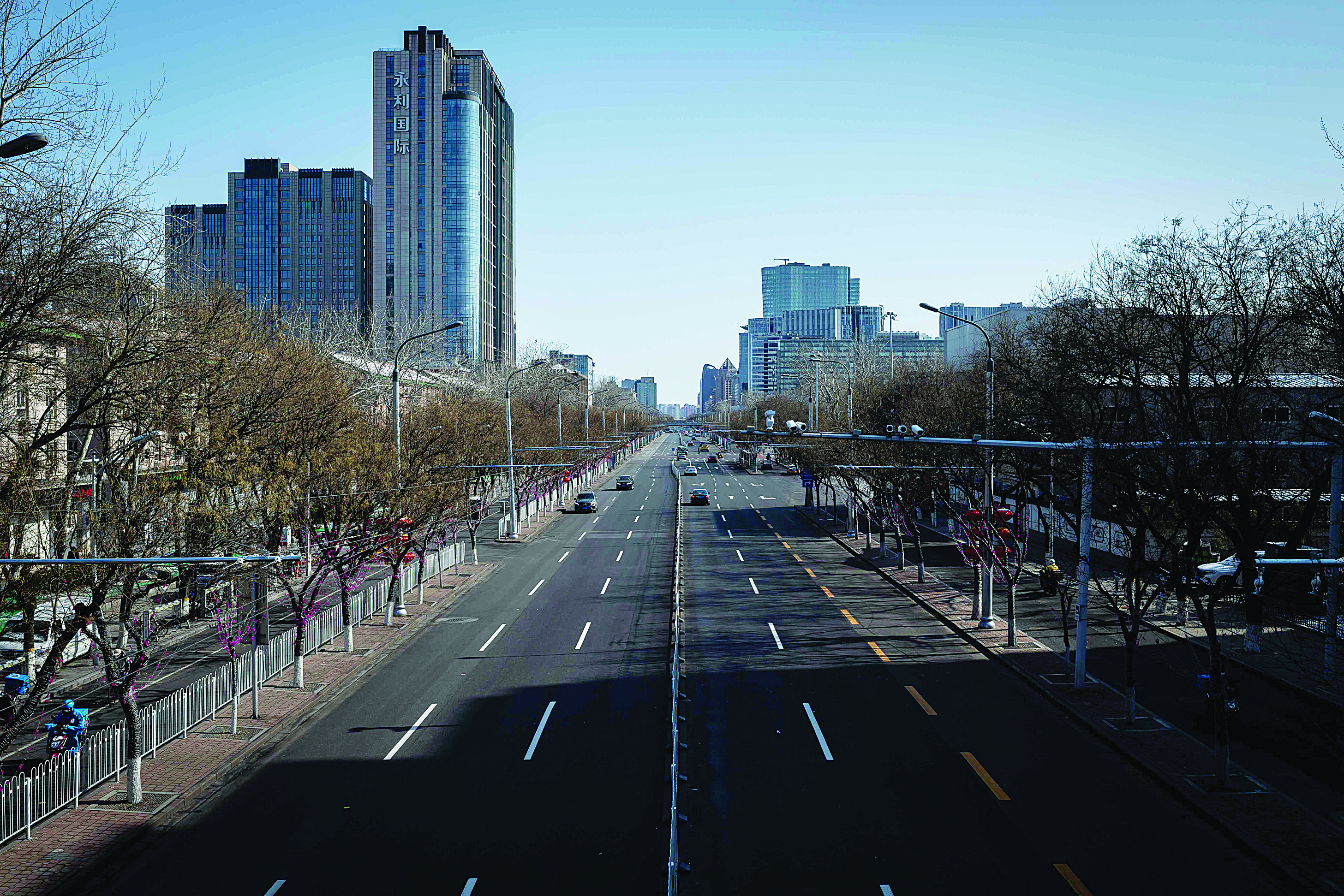 A nearly empty street is seen in Beijing on February 15, 2020. - The death toll from the new coronavirus outbreak jumped past 1,500 in China as France reported the first fatality outside Asia, fuelling global concerns about the epidemic (Photo by NICOLAS ASFOURI / AFP)