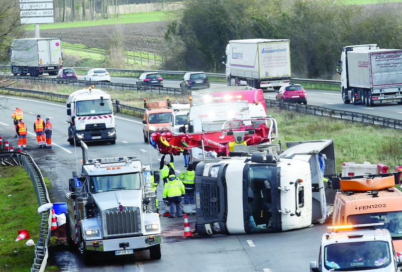 Rescuers work on the A2 motorway in Marly, northern France, after a truck was tipped over in the early morning from strong winds brought by storm Ciara on February 10, 2020. - Hundreds of flights and train services were cancelled on February 10 as Storm Ciara sweeps over northwest Europe packing powerful winds, and leaving swatches of Europe without power after unleashing torrential rain and causing flash flooding. (Photo by FRANCOIS LO PRESTI / AFP)