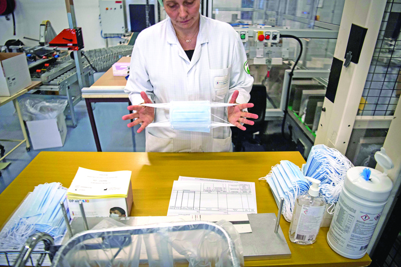 An employee controls health protection masks in a production chain of the Kolmi-Hopen company's factory, on February 1, 2020 in Saint-Barthelemy-d'Anjou, western France. - The company indicated receiving hundreds of millions of orders for health protection masks due to cases of coronavirus that emerged in a market in the central Chinese city of Wuhan. The coronavirus outbreak has so far killed more than 250 people and infected thousands in mainland China and beyond and has forced governments around the world to take drastic measures. (Photo by Loic VENANCE / AFP)