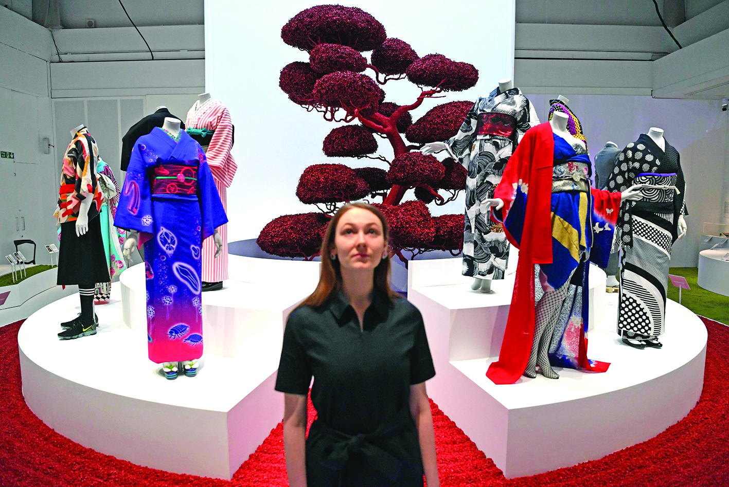 A museum employee poses next to kimonos displayed during the press preview of the 'Kimono: Kyoto to Catwalk' exhibition at the Victoria and Albert Museum in central London on February 26, 2020. (Photo by DANIEL LEAL-OLIVAS / AFP)