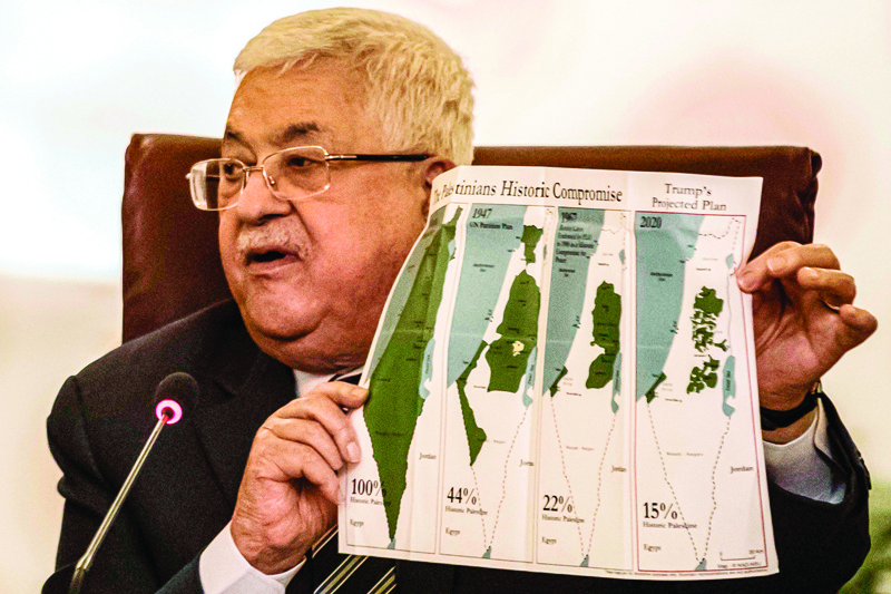 Palestinian president Mahmud Abbas holds a placard showing maps of (L to R) historical Palestine, the 1947 United Nations partition plan on Palestine, the 1948-1967 borders between the Palestinian territories and Israel, and a current map of the Palestinian territories without Israeli-annexed areas and settlements, as he attends an Arab League emergency meeting discussing the US-brokered proposal for a settlement of the Middle East conflict at the league headquarters in the Egyptian capital Cairo on February 1, 2020. (Photo by Khaled DESOUKI / AFP)
