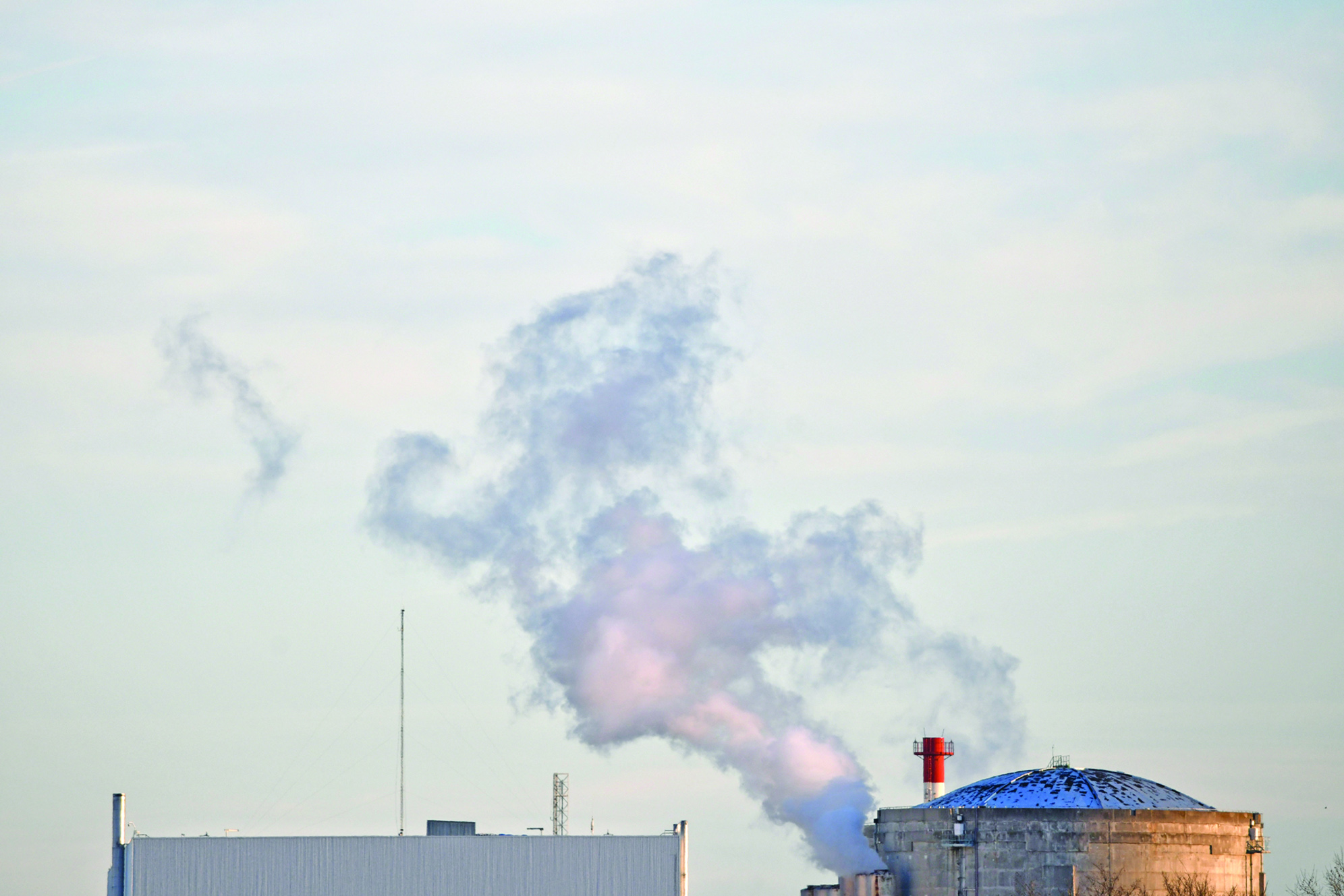Smoke rises from the Fessenheim nuclear powerplant in Fessenheim, eastern France, on February 22, 2020, following the closing of the first of the two reactors of the Fessenheim power plant overnight. - France started to close its oldest atomic power plant on early February 22 after 43 years in operation, the first in a series of reactor shutdowns but hardly a signal the country will reduce its reliance on nuclear energy anytime soon. Unplugging the two reactors at Fessenheim, along the Rhine near France's eastern border with Germany and Switzerland, became a key goal of anti-nuclear campaigners after the catastrophic meltdown at Fukushima in Japan in 2011. The first reactor was shut down on early February 22 and the second will be closed on June 30, though it will be several months before they go cold and the used fuel can start to be removed. (Photo by SEBASTIEN BOZON / AFP)