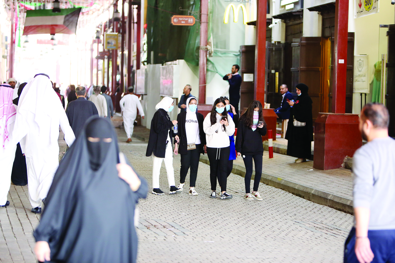 Kuwaiti women wearing protective masks walk inside the Mubarakiya Market in Kuwait City on February 24, 2020.