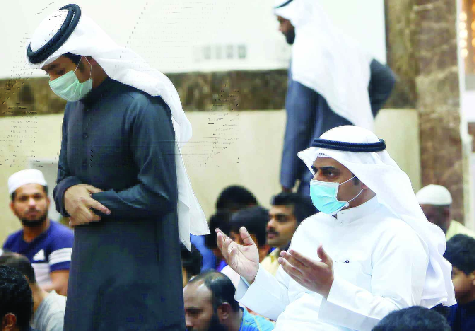 Muslim men wearing protective masks during Friday prayers in Kuwait City on February 28, 2020. Kuwait's Ministry of Awqaf and Islamic Affairs set the Friday prayer sermon to not exceed 10 minutes, and discuss precautions against coronavirus infection.