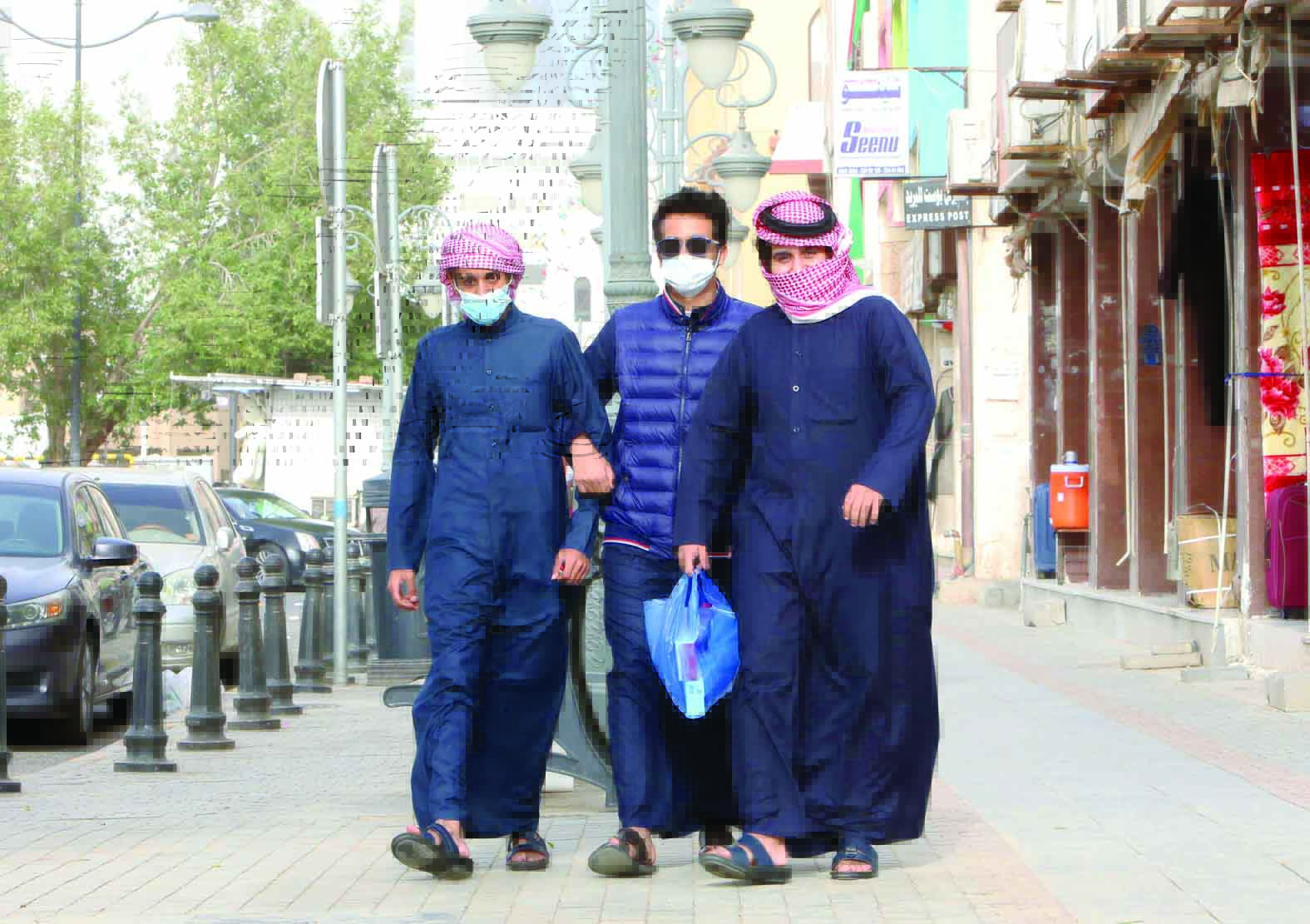 Kuwaitis wearing protective masks as they shops in Kuwait City on February 26, 2020.
