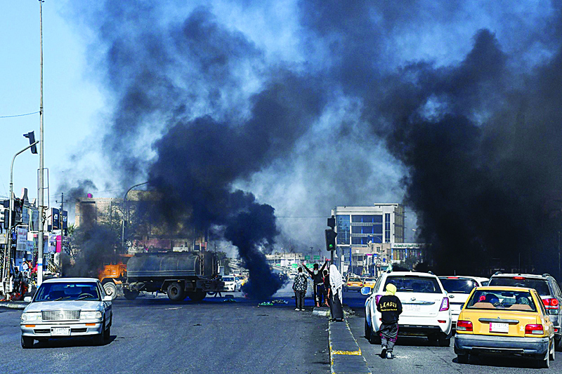 Iraqi Anti-government demonstrators block a road with burning tires in the southern Iraqi city of Nasiriyah on February 3, 2020 during a demonstration against the new Iraqi prime minister designate. - Allawi was named prime minister-designate after a hard-won consensus among Iraq's rival parties, who had struggled to agree on a candidate since outgoing premier Adel Abdel Mahdi resigned under growing street pressure two months ago. Mass rallies have rocked Baghdad and the mainly-Shiite south since October, with protesters demanding snap elections and an independent prime minister as well as accountability for corruption and recent bloodshed. (Photo by Asaad NIAZI / AFP)