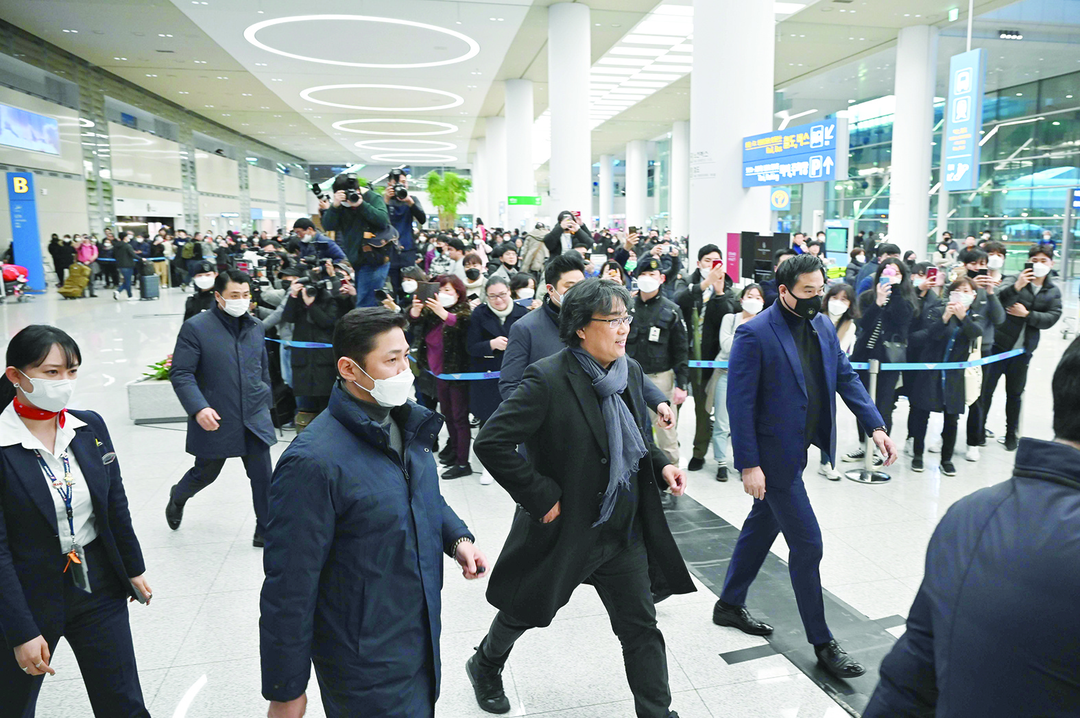 South Korean director Bong Joon-ho (centre R) walks past the media upon his arrival at Incheon airport, west of Seoul, on February 16, 2020 after his film Parasite won the Oscar for Best Picture. - Bong's movie Parasite -- about the widening gap between rich and poor -- became the first non-English-language film to win Hollywood's biggest prize on February 10, prompting celebrations in South Korea. (Photo by Ed JONES / AFP)