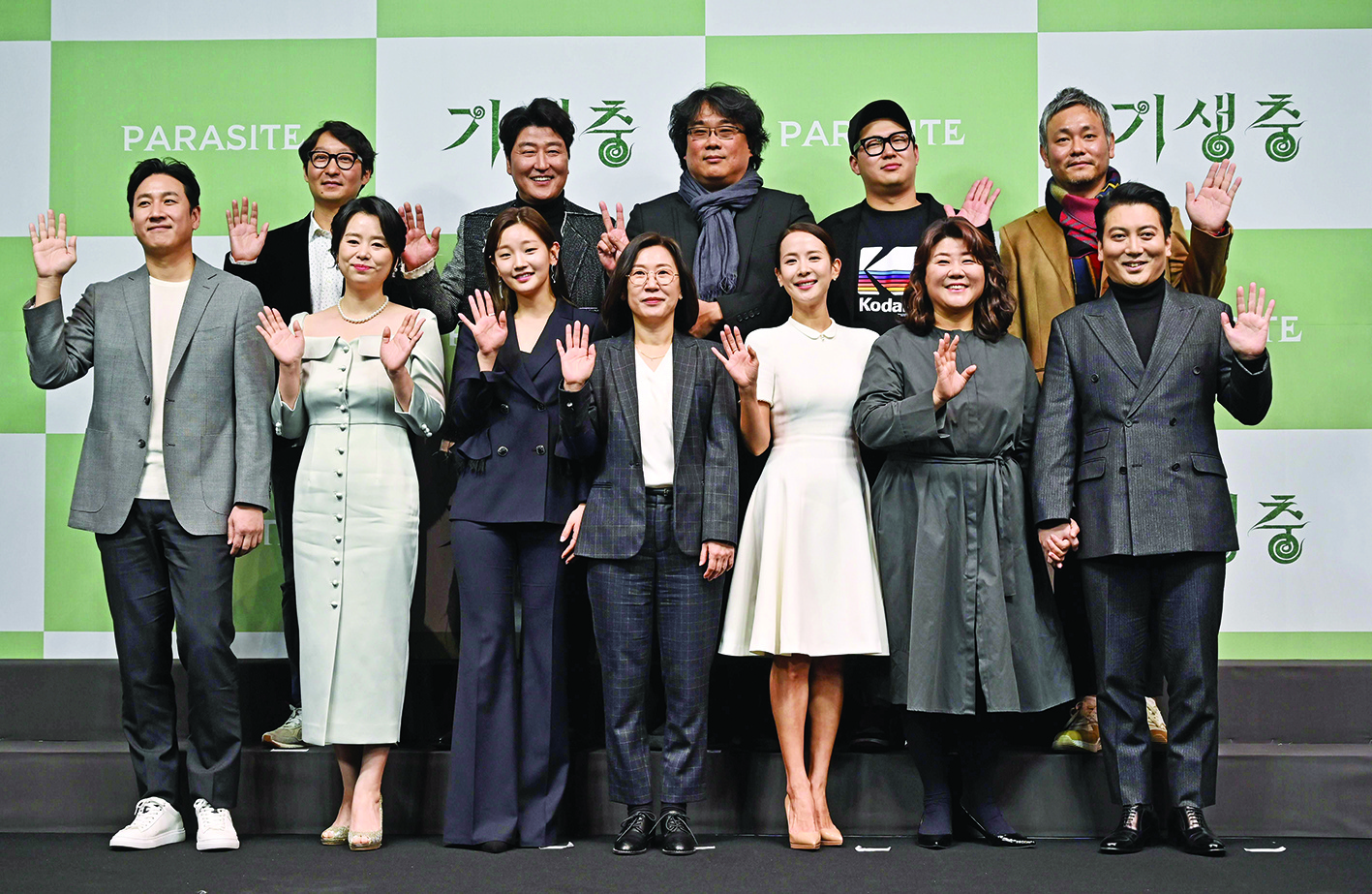 South Korean director Bong Joon-ho (top C) poses with the cast and crew members of the film Parasite during a press conference in Seoul on February 19, 2020, after his film won the Oscar for Best Picture. - Bong's movie Parasite -- about the widening gap between rich and poor -- became the first non-English-language film to win Hollywood's biggest prize on February 10, prompting celebrations in South Korea. (Photo by Jung Yeon-je / AFP)