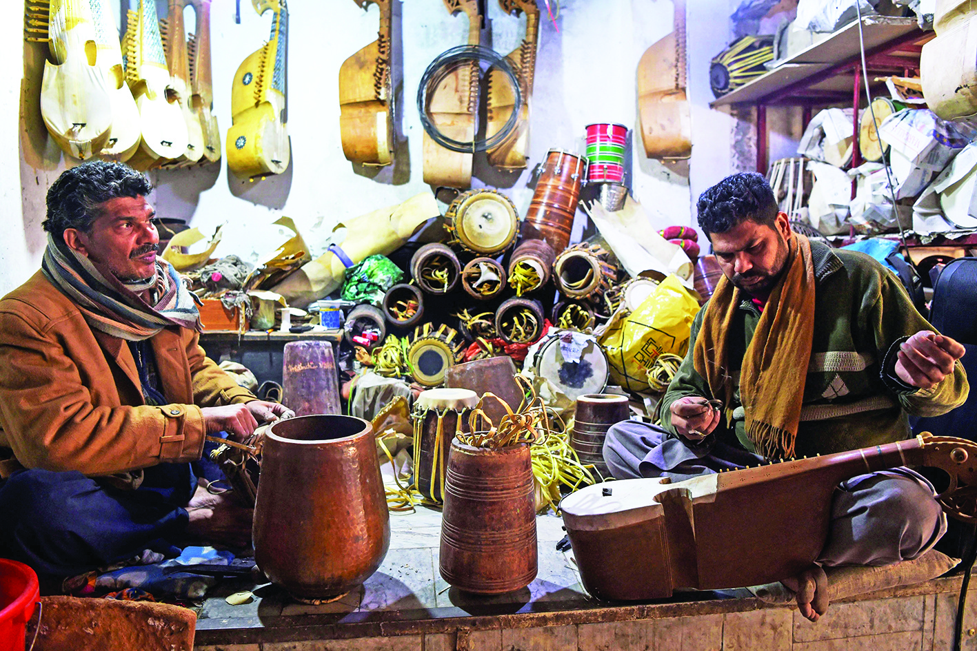 In this picture taken on December 3, 2019, workers make traditional rabab musical instruments in a workplace on the outskirts of Peshawar. - For years the distinctive twang of Pashtun music was drowned out by rattling gunfire and deafening explosions as musicians in Pakistan's northwest were targeted by militants. But, as security improves, a centuries-old tribal tradition is staging a comeback. (Photo by Abdul MAJEED / AFP) / TO GO WITH Pakistan-Taliban-militancy-music-culture,FOCUS by David STOUT and Sajjad TARAKZAI