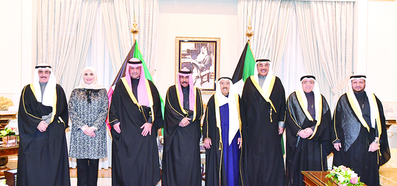 KUWAIT: HH the Amir Sheikh Sabah Al-Ahmad Al-Jaber Al-Sabah and HH the Crown Prince Sheikh Nawaf Al-Ahmad Al-Jaber Al-Sabah pose for a group photo with HH the Prime Minister Sheikh Sabah Al-Khaled Al-Hamad Al-Sabah and the newly-appointed ministers yesterday. - KUNA
