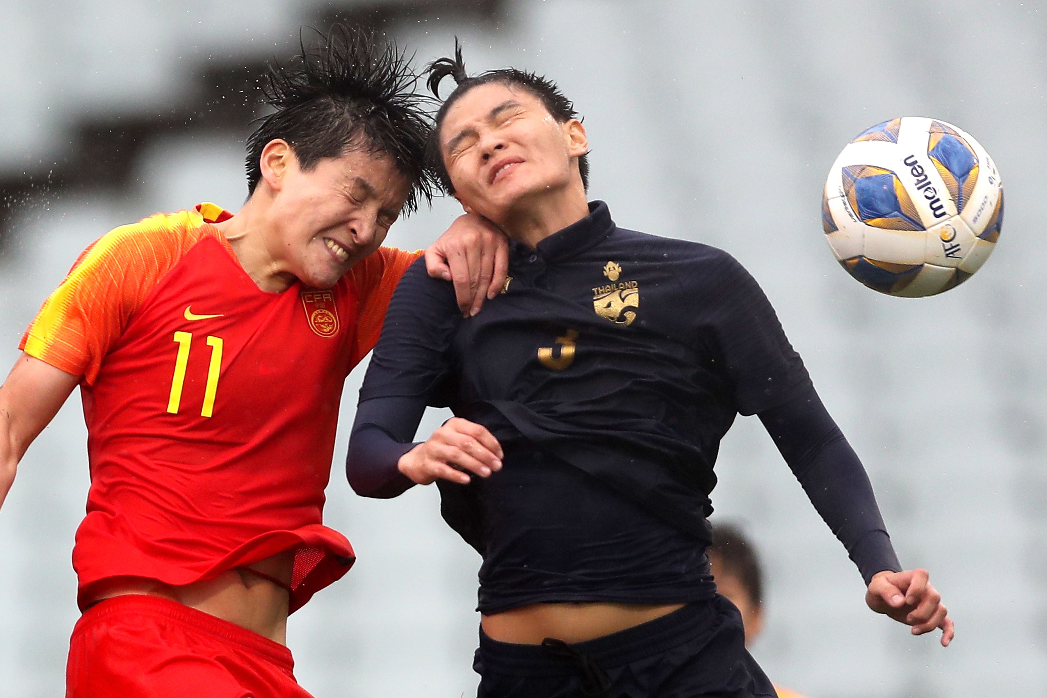 (FILES) This file photo taken on February 7, 2020 shows China's Wang Shanshan (L) and Thailand's Natthakarn Chinwong competing for the ball during the women's Olympic football tournament qualifier match between China and Thailand at Campbelltown Stadium in Sydney on February 7, 2020. - The coronavirus has destroyed the Tokyo Olympic dreams of some Chinese athletes and disrupted the preparations of others, forcing them to miss tournaments and train in strict isolation -- sometimes in masks. (Photo by JEREMY NG / AFP) / RO GO WITH: China health virus Oly 2020 CHN, FOCUS by Peter STEBBINGS      nn -- IMAGE RESTRICTED TO EDITORIAL USE - STRICTLY NO COMMERCIAL USE --