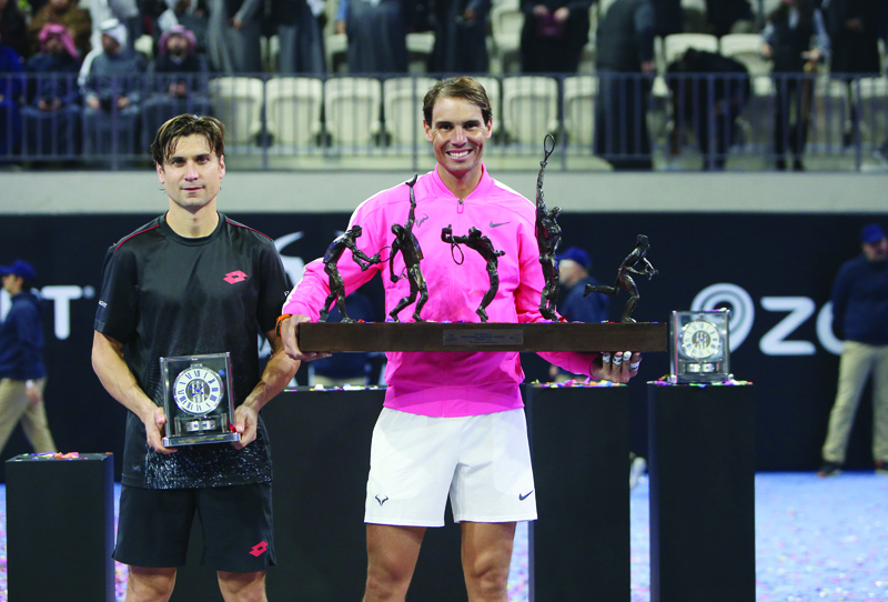 Rafael Nadal of Spain (R) holds his trophy after winning an exhibition game against compatriot David Ferrer, to inaugurate the Rafa Nadal Academy Kuwait, at Shaikh Jaber Al Abdullah Al Jaber Al Sabah International Tennis Complex in the Kuwaiti capital, on February 5, 2020. (Photo by Yasser Al-Zayyat / AFP)