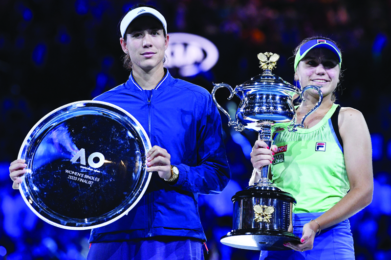 Sofia Kenin (R) of the US poses with the Daphne Akhurst Memorial Cup along with runner-up Spain's Garbine Muguruza after their women's singles final match on day thirteen of the Australian Open tennis tournament in Melbourne on February 1, 2020. (Photo by Saeed KHAN / AFP) / IMAGE RESTRICTED TO EDITORIAL USE - STRICTLY NO COMMERCIAL USE