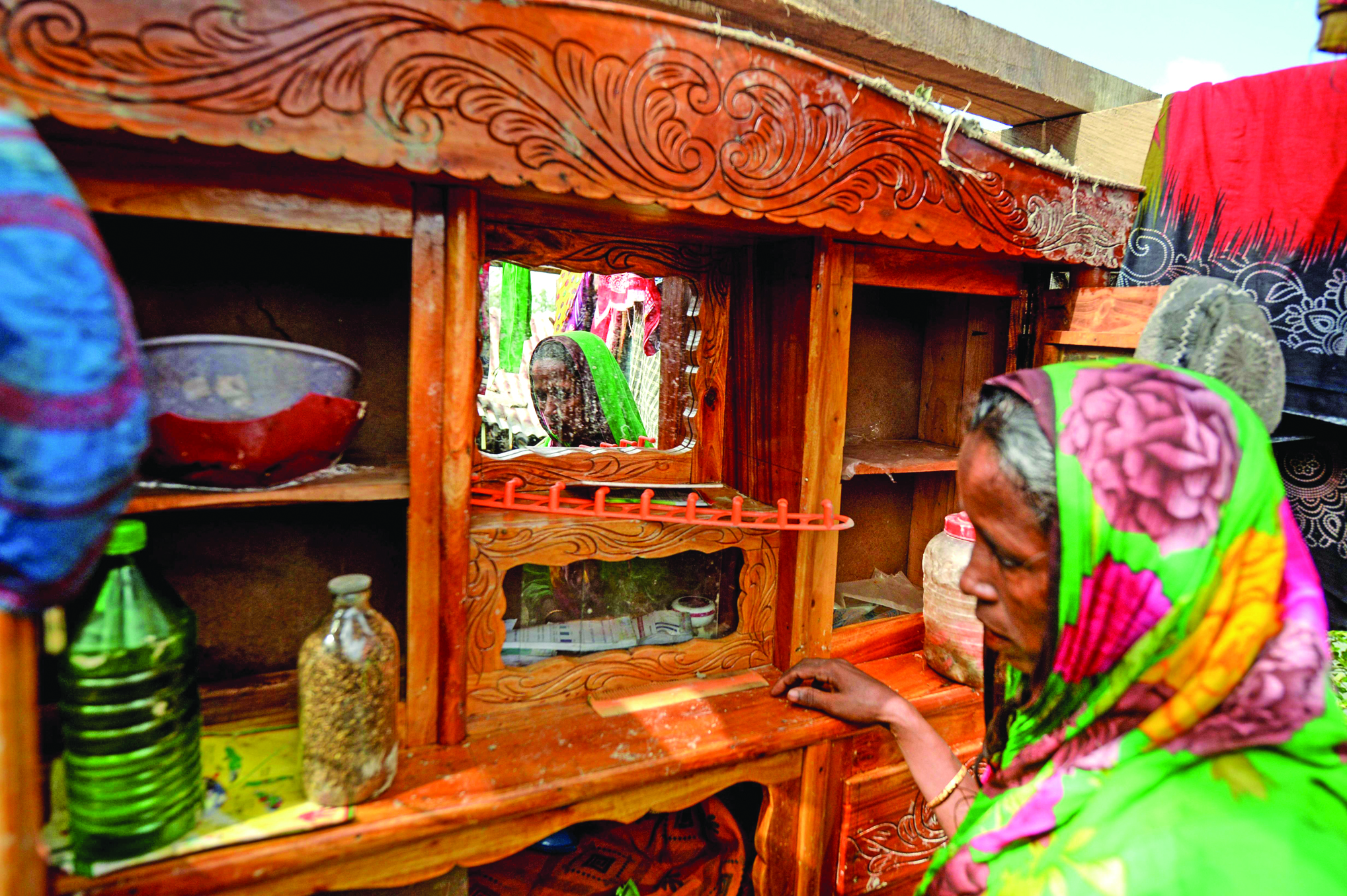 In this photograph taken on November 11, 2019, Bangladeshi mother-of-four Mosammat Rashida, whose husband was killed by a Bengal tiger a decade ago while he was collecting honey, stands next to a mirror at her house in Shyamnagar. - Women whose husbands have been killed by the Bengal tiger are shunned in Bangladesh by superstitious villagers who believe they are bad omens who should be blamed for their spouse's untimely death. (Photo by Munir UZ ZAMAN / AFP) / TO GO WITH Bangladesh-women-animal-environment,FOCUS by Sam Jahan