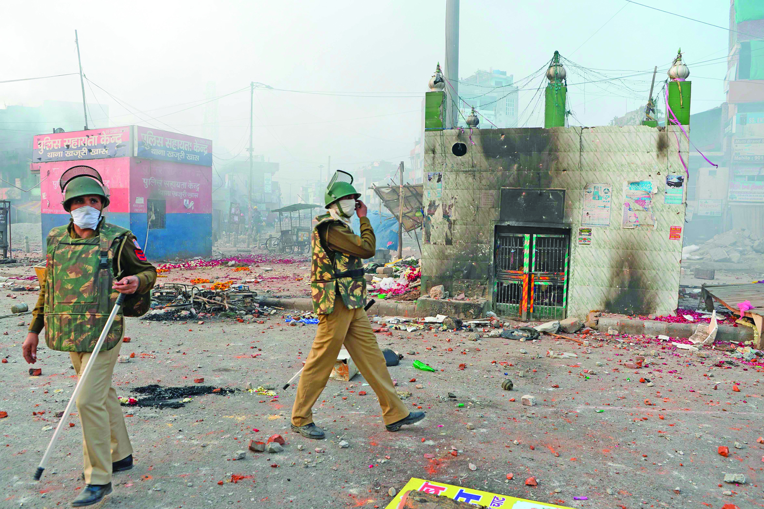 Policemen stand on a vandalised road following clashes between supporters and opponents of a new citizenship law, at Bhajanpura area of New Delhi on February 24, 2020, ahead of US President arrival in New Delhi. - Fresh clashes raged in New Delhi in protests over a contentious citizenship law on February 24, hours ahead of a visit to the Indian capital by US President Donald Trump. India has seen weeks of demonstrations and violence since a new citizenship law -- that critics say discriminates against Muslims -- came into force in December. (Photo by Sajjad HUSSAIN / AFP)