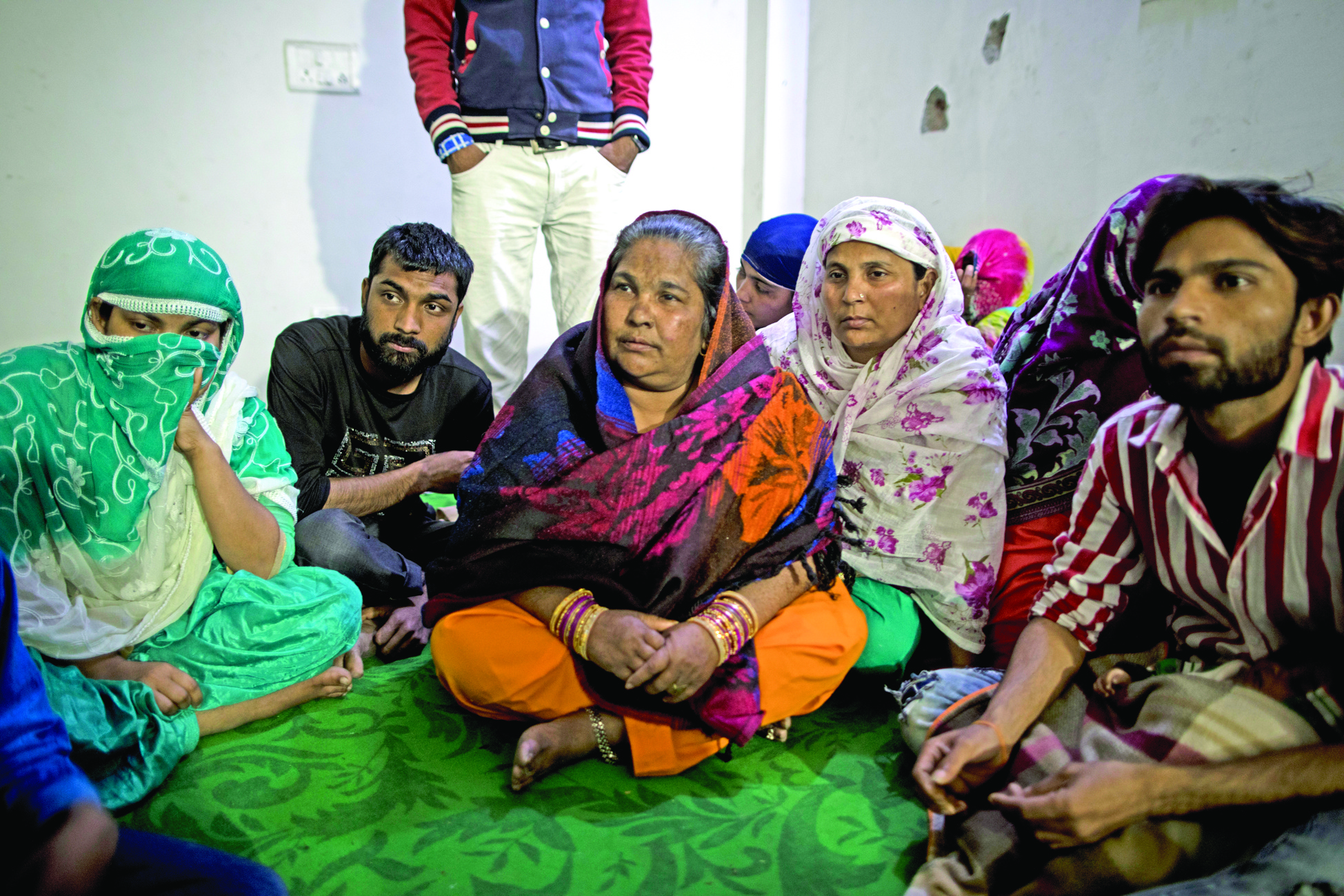 Parveen (C) sits with relatives and other families at Al-hind Hospital where they have taken shelter with other families after losing their homes following sectarian riots over India's new citizenship law, in New Delhi on February 28, 2020. - Muslims in India's capital held regular Friday prayers on February 28 under the watch of riot police, capping a week which saw 42 killed and hundreds injured during the city's worst sectarian violence in decades. (Photo by Xavier GALIANA / AFP)