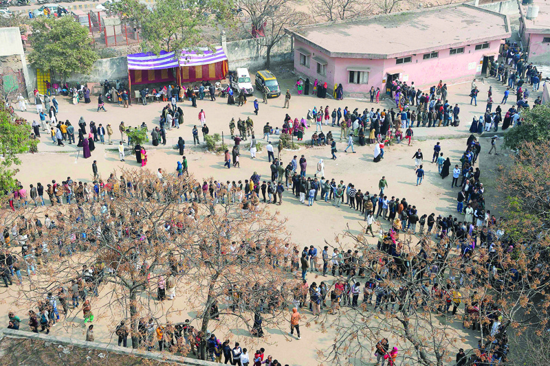 TOPSHOT - People queue at a polling station to cast their votes during the Legislative Assembly elections in New Delhi on February 8, 2020. (Photo by Sajjad HUSSAIN / AFP)