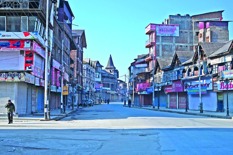 TOPSHOT - Kashmiri pedestrian walks along a street in central Lal Chowk area during a one-day strike called by Jammu and Kashmir Libration Front (JKLF) to demand the return of the remains of Afzal Guru, who was executed in 2013 over the Indian parliament attack in 2001, in Srinagar on February 9, 2020. (Photo by TAUSEEF MUSTAFA / AFP)