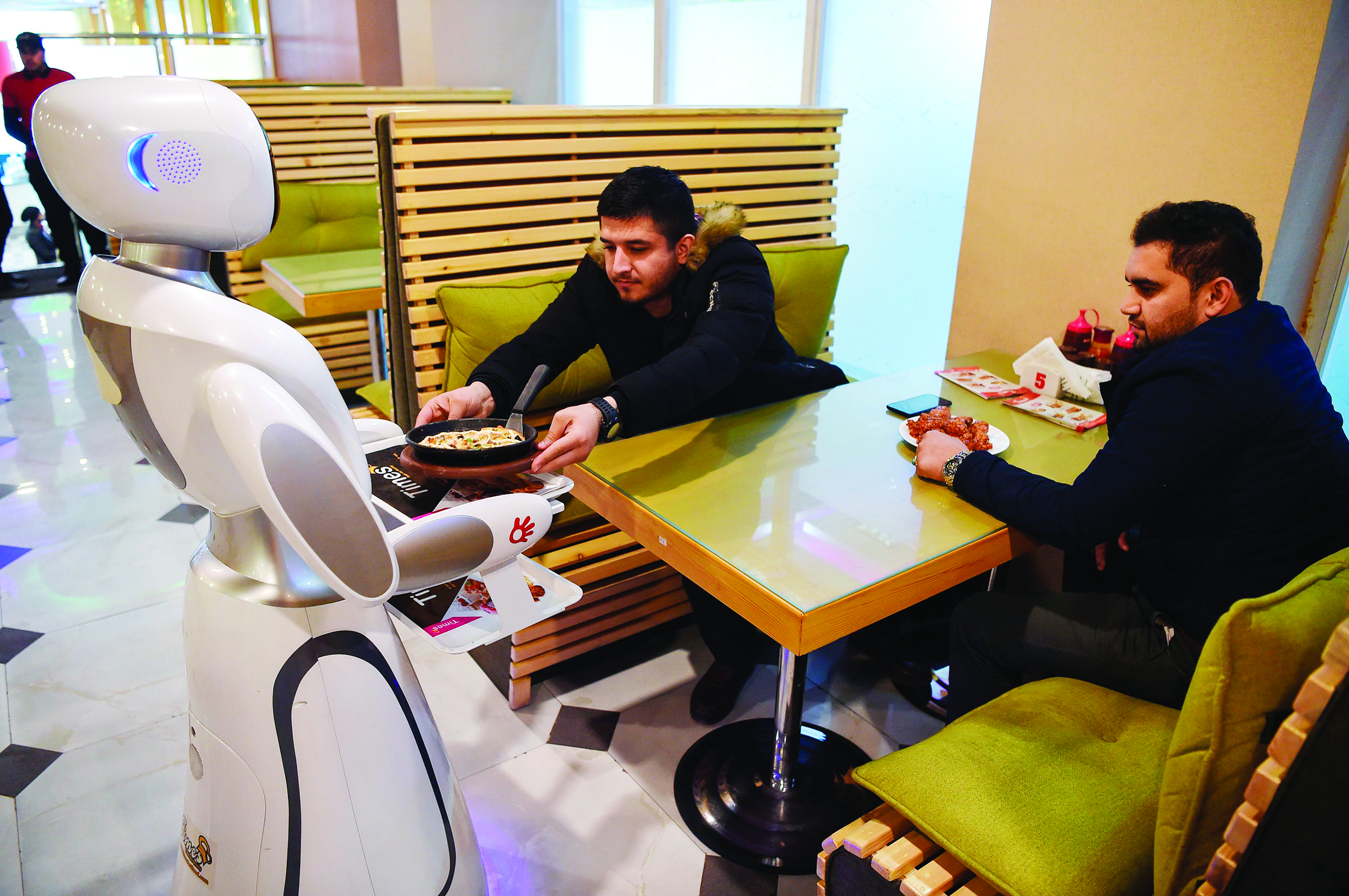 A waitress robot, named Timea, delivers food to customers at a fast food restaurant in Kabul on February 13, 2020. (Photo by WAKIL KOHSAR / AFP)
