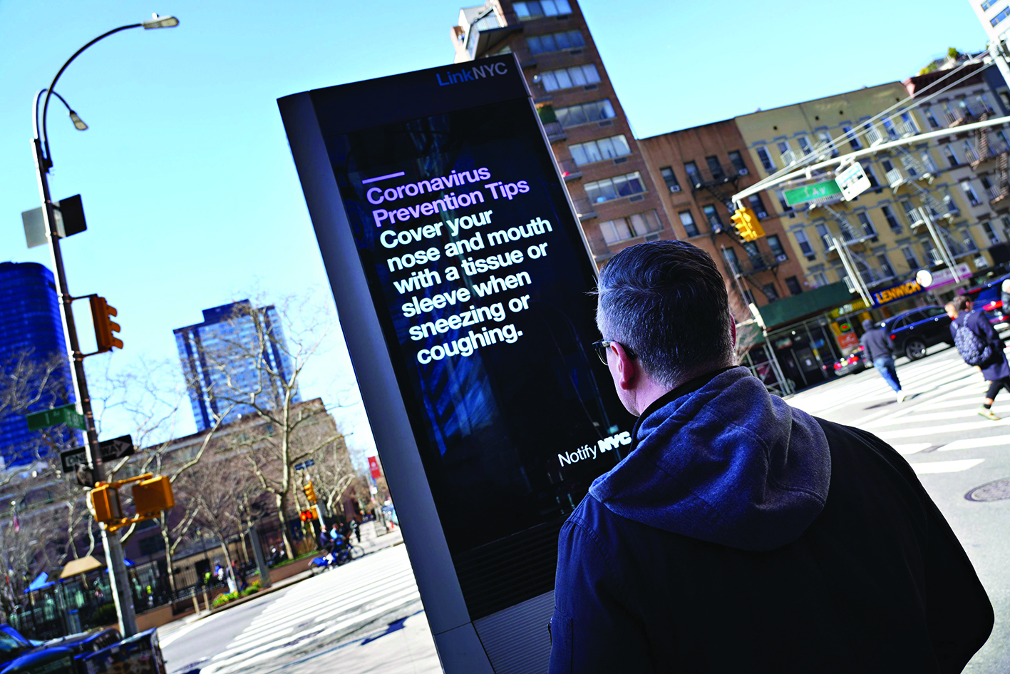 NEW YORK, - MARCH 15: A man reads a coronavirus prevention tip displayed on a LinkNYC box as the coronavirus continues to spread across the United States on March 15, 2020 in New York City. The World Health Organization declared coronavirus (COVID-19) a global pandemic on March 11th.   Cindy Ord/Getty Images/AFPn== FOR NEWSPAPERS, INTERNET, TELCOS &amp; TELEVISION USE ONLY ==