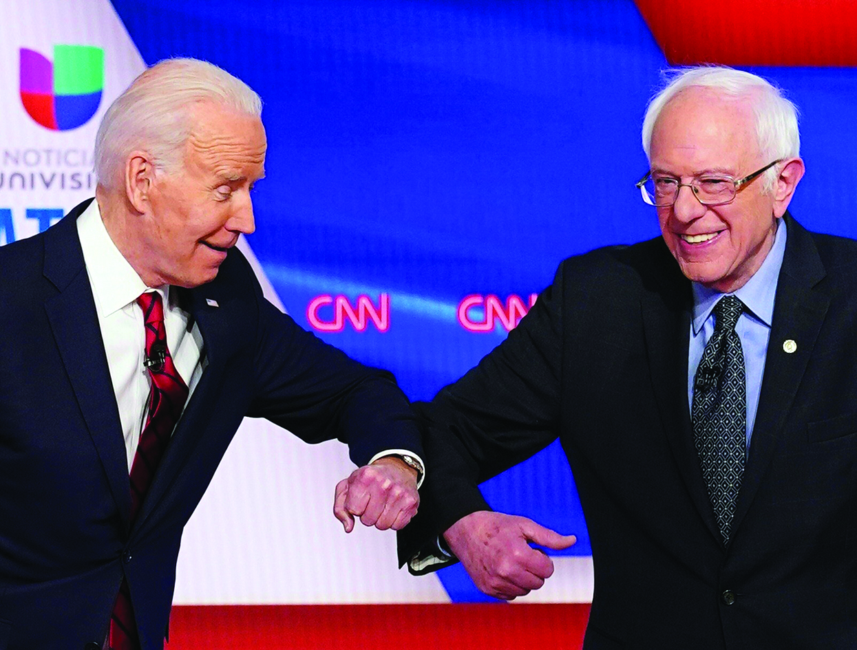 TOPSHOT - Democratic presidential hopefuls former US vice president Joe Biden (L) and Senator Bernie Sanders greet each other with a safe elbow bump before the start of the 11th Democratic Party 2020 presidential debate in a CNN Washington Bureau studio in Washington, DC on March 15, 2020. (Photo by Mandel NGAN / AFP)