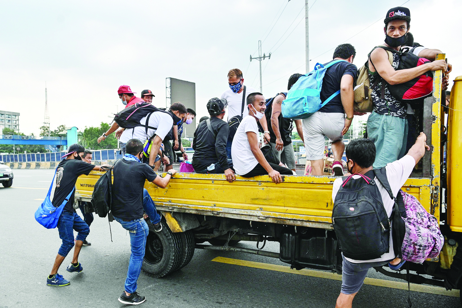 Residents get into a truck for a free ride home in Manila on March 17, 2020, as the government imposed measures to curb the spread of the COVID-19 coronavirus, including suspending all public transport on the main Luzon island. - Philippine President Rodrigo Duterte ordered about half the country's population to stay home for the next month in a drastic bid on March 16 to curb the rising number of new coronavirus cases. (Photo by Ted ALJIBE / AFP)