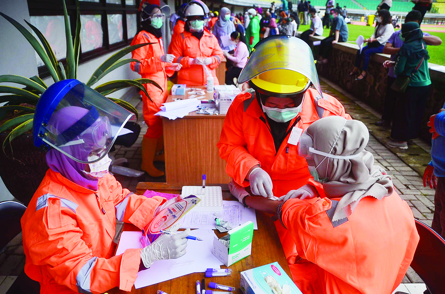 Indonesian medical staff take part in a mass test for the COVID-19 coronavirus at Patriot stadium in Bekasi, West Java on March 25, 2020. (Photo by REZAS / AFP)