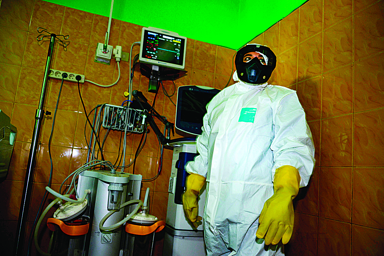 A health worker wearing a protective gear checks a quarantine room at a hospital in Banda Aceh on March 4, 2020. (Photo by CHAIDEER MAHYUDDIN / AFP)