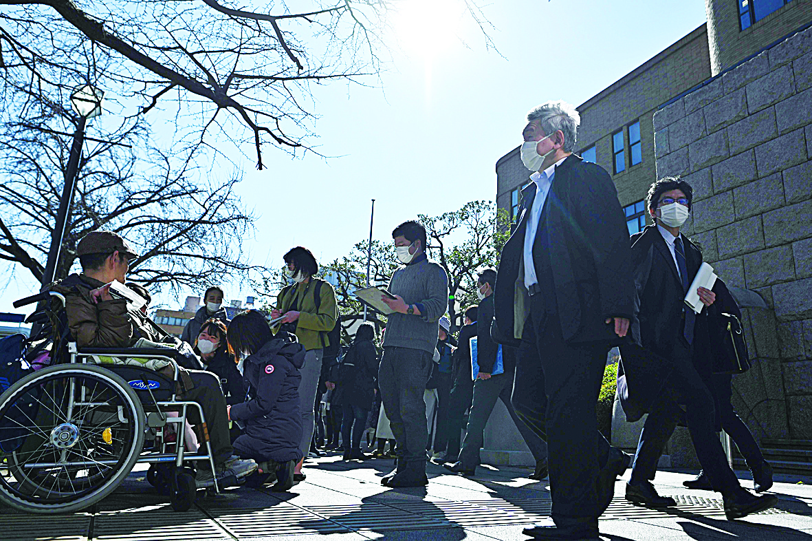 Journalists gather outside the Yokohama district court on March 16, 2020, after the court sentenced Satoshi Uematsu, accused of murdering 19 disabled people at a care facility in the town of Sagamihara in 2016, to death. - A court in Japan on March 16, 2020 sentenced Satoshi Uematsu to the death penalty for the murder of 19 people in a stabbing attack at the care home for disabled people in Sagamihara, Kanagawa prefecture. (Photo by Philip FONG / AFP)