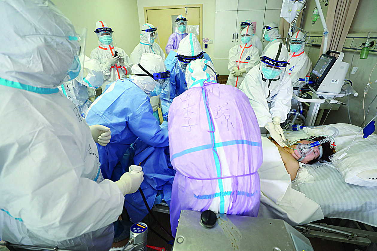 TOPSHOT - Medical staff treating a critical patient infected by the COVID-19 coronavirus with an Extracorporeal membrane oxygenation (ECMO) at the Red Cross hospital in Wuhan in China's central Hubei province on March 1, 2020. - China on March 1 reported 35 more deaths from the new coronavirus, taking the toll in the country to 2,870. (Photo by STR / AFP) / China OUT
