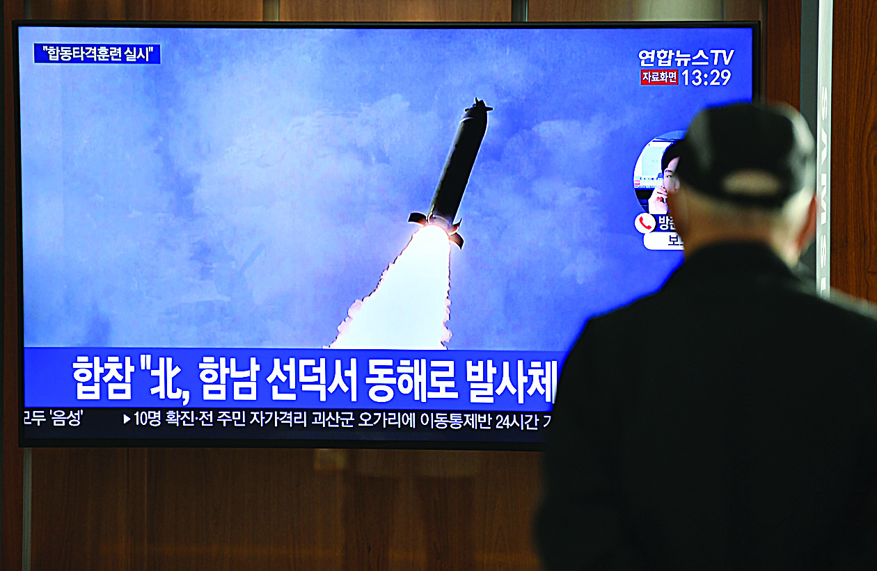 TOPSHOT - A man watches a television news broadcast showing a file image of a North Korean missile test, at a railway station in Seoul on March 9, 2020. - Nuclear-armed North Korea on March 9 fired what Japan said appeared to be ballistic missiles, a week after a similar weapons test by Pyongyang. (Photo by Jung Yeon-je / AFP)