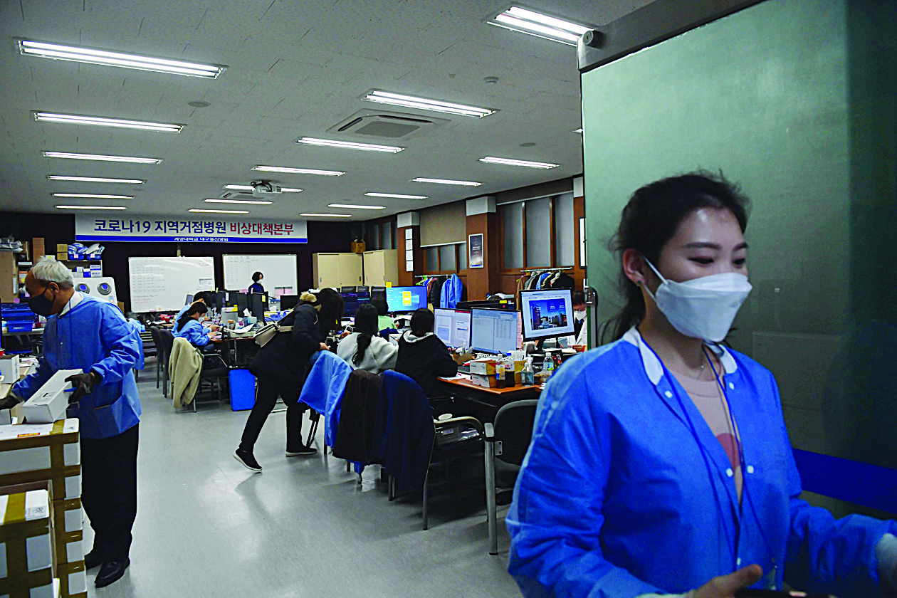 Hospital workers track responses to the COVID-19 novel coronavirus at a situation room at a hospital in Daegu on March 10, 2020. - South Korea, one of the worst-affected countries in the coronavirus epidemic outside China, on March 10 reported fewer than 150 new cases for the first time in two weeks. (Photo by ED JONES / AFP)
