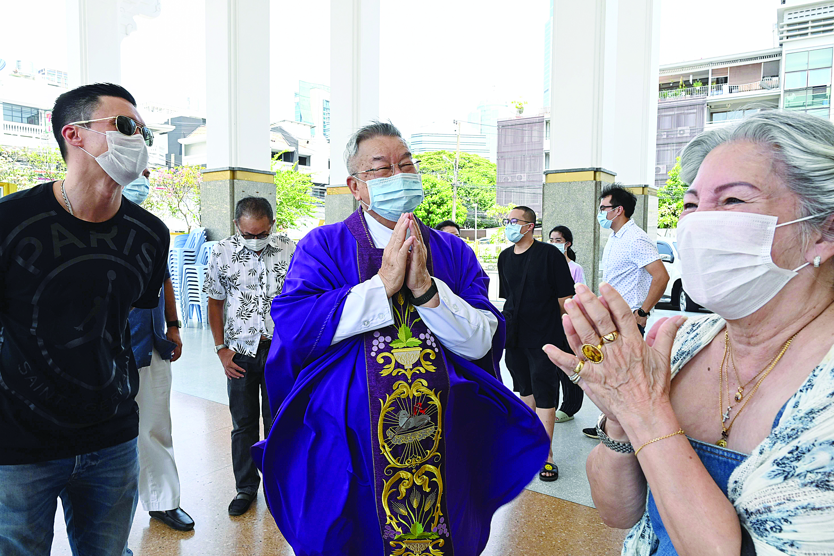 Father Paul Nettham (C), wearing a face mask as a preventive measure against the spread of the COVID-19 novel coronavirus, greets devotees after a mass at the Holy Redeemer church in Bangkok on March 22, 2020. (Photo by Romeo GACAD / AFP)