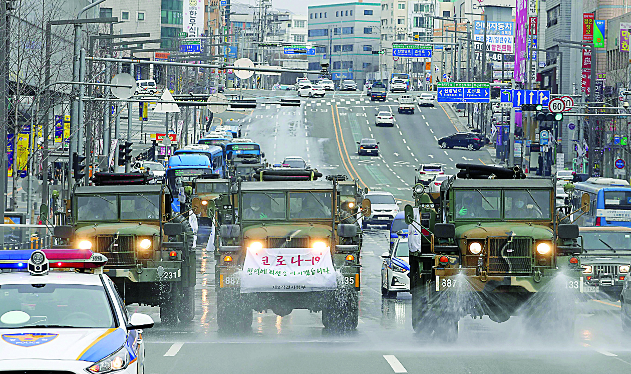Military vehicles spray disinfectant as part of preventive measures against the spread of the COVID-19 coronavirus, on a road near Dongdaegu railway station in Daegu on February 29, 2020. - South Korea confirmed 594 more coronavirus cases on February 29, the biggest increase to date for the country and taking the national total to 2,931 infections with three additional deaths. (Photo by - / YONHAP / AFP) / - South Korea OUT / REPUBLIC OF KOREA OUT  NO ARCHIVES  RESTRICTED TO SUBSCRIPTION USE