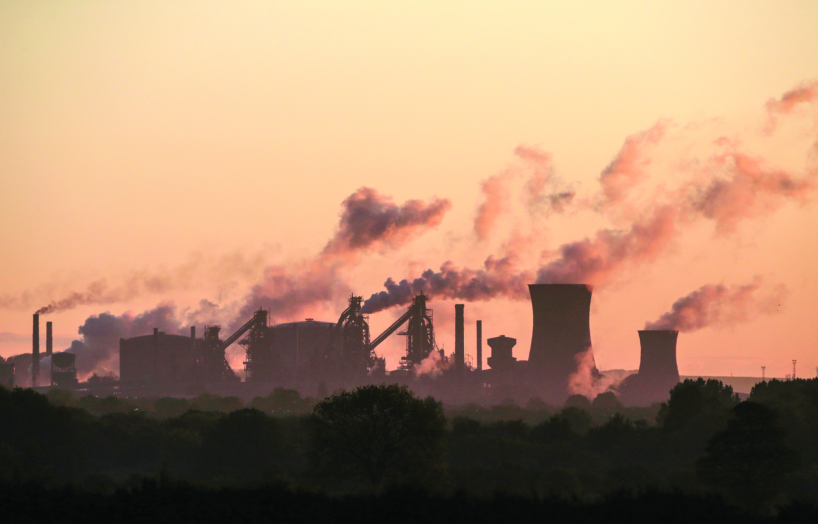 (FILES) In this file photo taken on May 22, 2019, vapour is pictured rising from British Steel's Scunthorpe plant at dawn in north Lincolnshire, north east England - UK manufacturing activity rebounded in February to a ten-month high on easing Brexit uncertainty, but supply chains were nevertheless pressured by coronavirus concerns, data showed on March 2, 2020. The IHS Markit UK Manufacturing purchasing managers' index (PMI) stood at 51.7 last month, the group said in a statement. (Photo by Lindsey Parnaby / AFP)