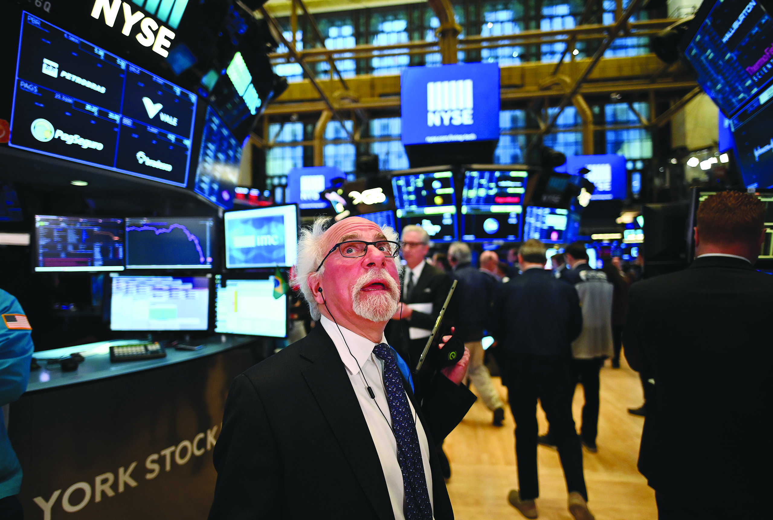 Traders work during the opening bell at the New York Stock Exchange (NYSE) on March 16, 2020 at Wall Street in New York City. - Wall Street trading halted after the opening bell on deep losses. (Photo by Johannes EISELE / AFP)