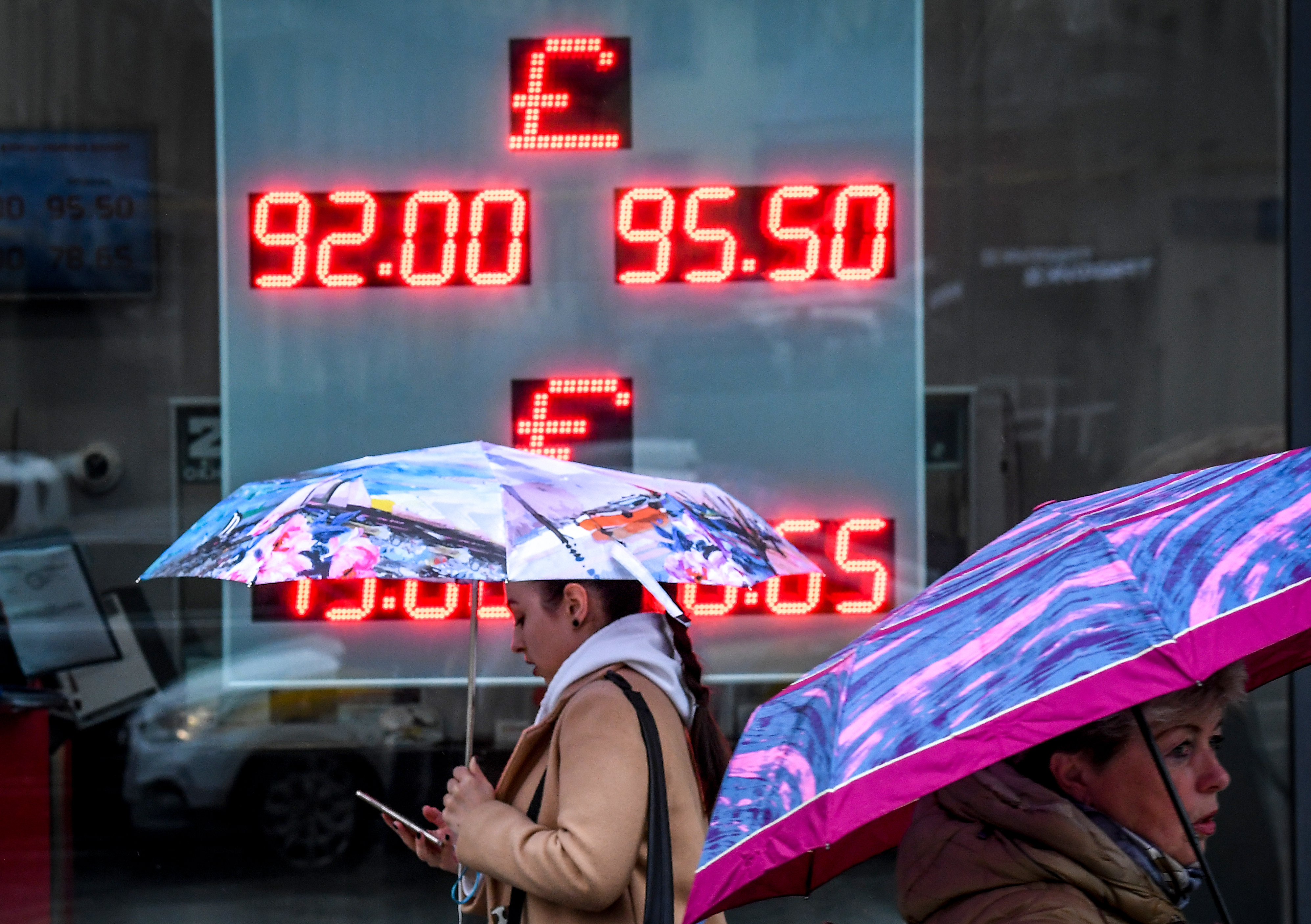 Women walk past a currency exchange office in Moscow on March 10, 2020. - Russia's RTS stock index dived more than 10 percent on opening March 10 after a public holiday, following a crash in oil prices that saw the ruble and global markets post massive losses. The Russian ruble tumbled in value March 9 to trade at 75 to the US dollar, a rate last seen in early 2016. On March 10, it rose slightly and was trading at around 72 to the dollar and 82 to the euro. (Photo by Yuri KADOBNOV / AFP)