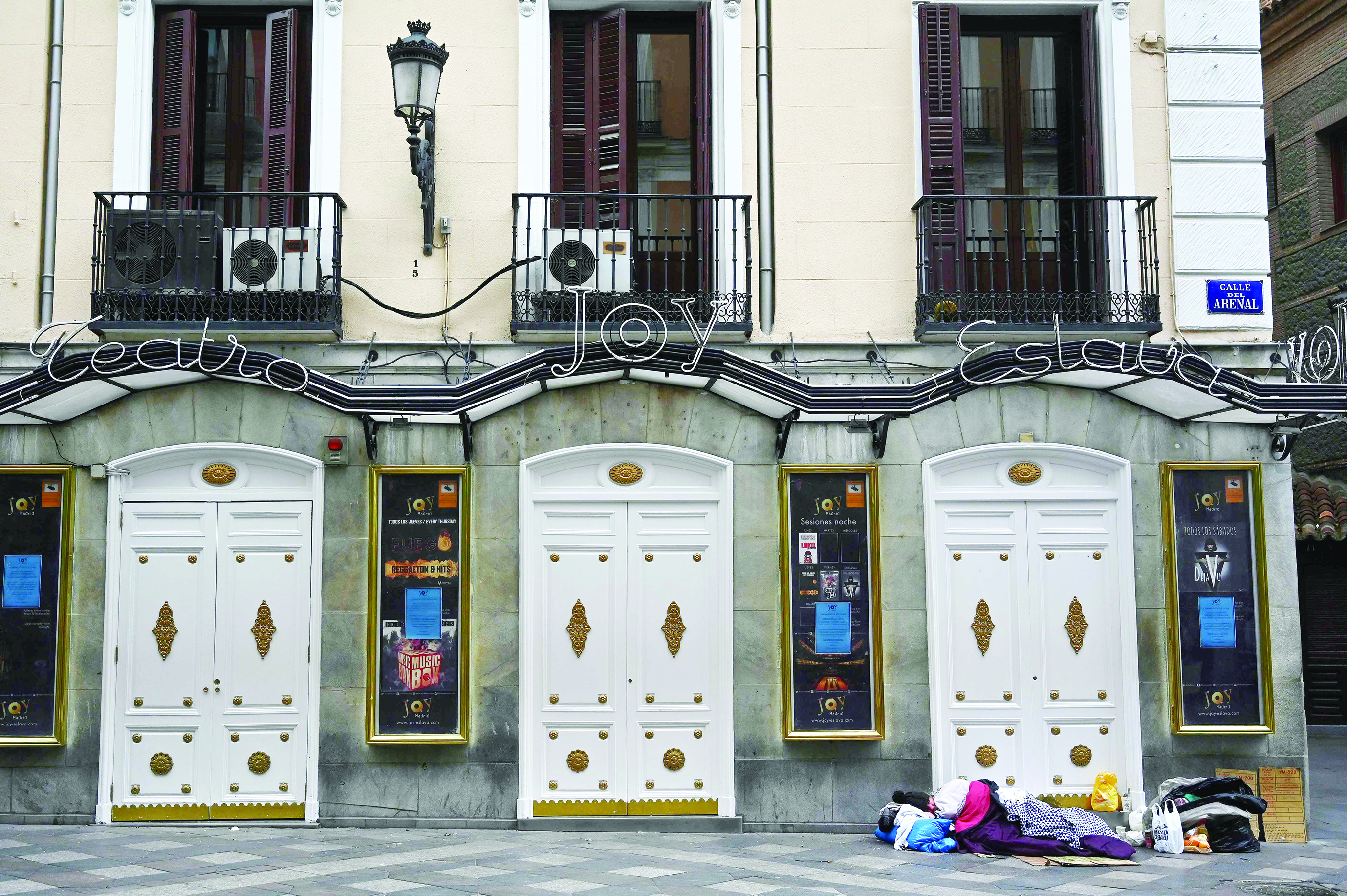 A homeless man sleeps in a deserted street in Madrid on March 27, 2020 amid a national lockdown to fight the spread of the COVID-19 coronavirus. - The death toll in Spain soared over 4,800 after 769 people died in 24 hours, in what was a record one-day figure for fatalities in the country. (Photo by Gabriel BOUYS / AFP)