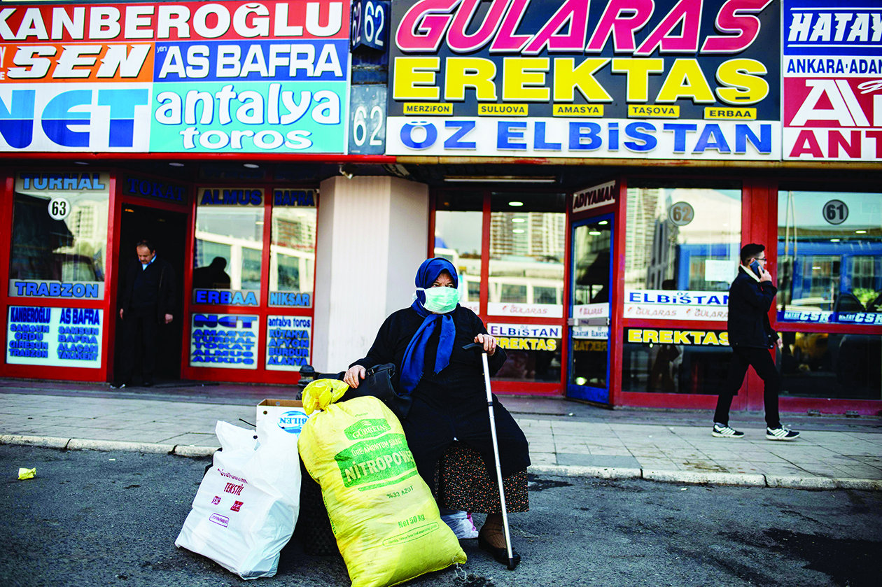 A woman wearing a protective face mask waits at the Esenler bus terminal in Istanbul, on March 14, 2020, during the outbreak of COVID-19, the new coronavirus. - Turkey will halt flights with nine European countries the transport minister said on March 13, after having already shut all schools for two weeks and bar spectators from football matches through April, as part of Ankara's bid to contain the spread of the new coronavirus. (Photo by Yasin AKGUL / AFP)