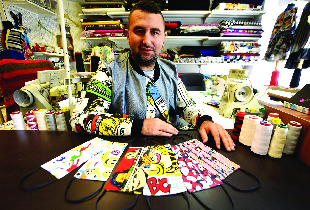 A pcture taken on March 03, 2020 in Zagreb shows Croatian designer Zoran Aragovic posing next to protective face masks bearing his designs. - Triggered by coronavirus epidemic he designed mask of cotton in his distictivepop art style. (Photo by Denis LOVROVIC / AFP)