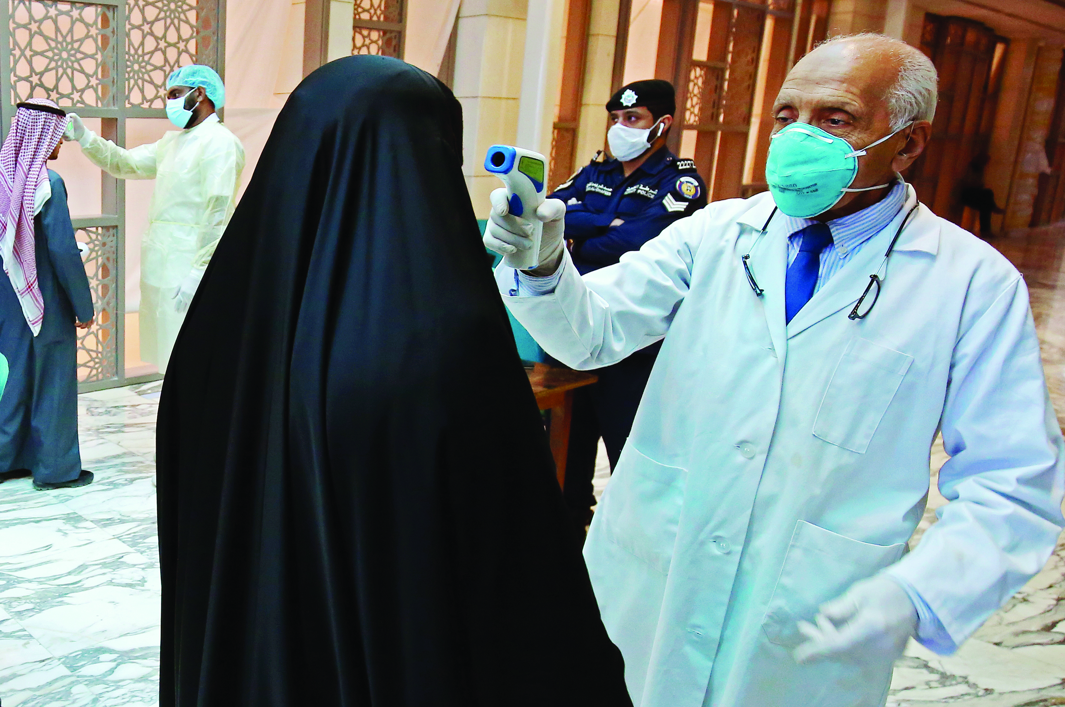 Kuwait health ministry workers scan employees and visitors of the ministries complex, as they arrive to their work, in Kuwait City on March 3, 2020.