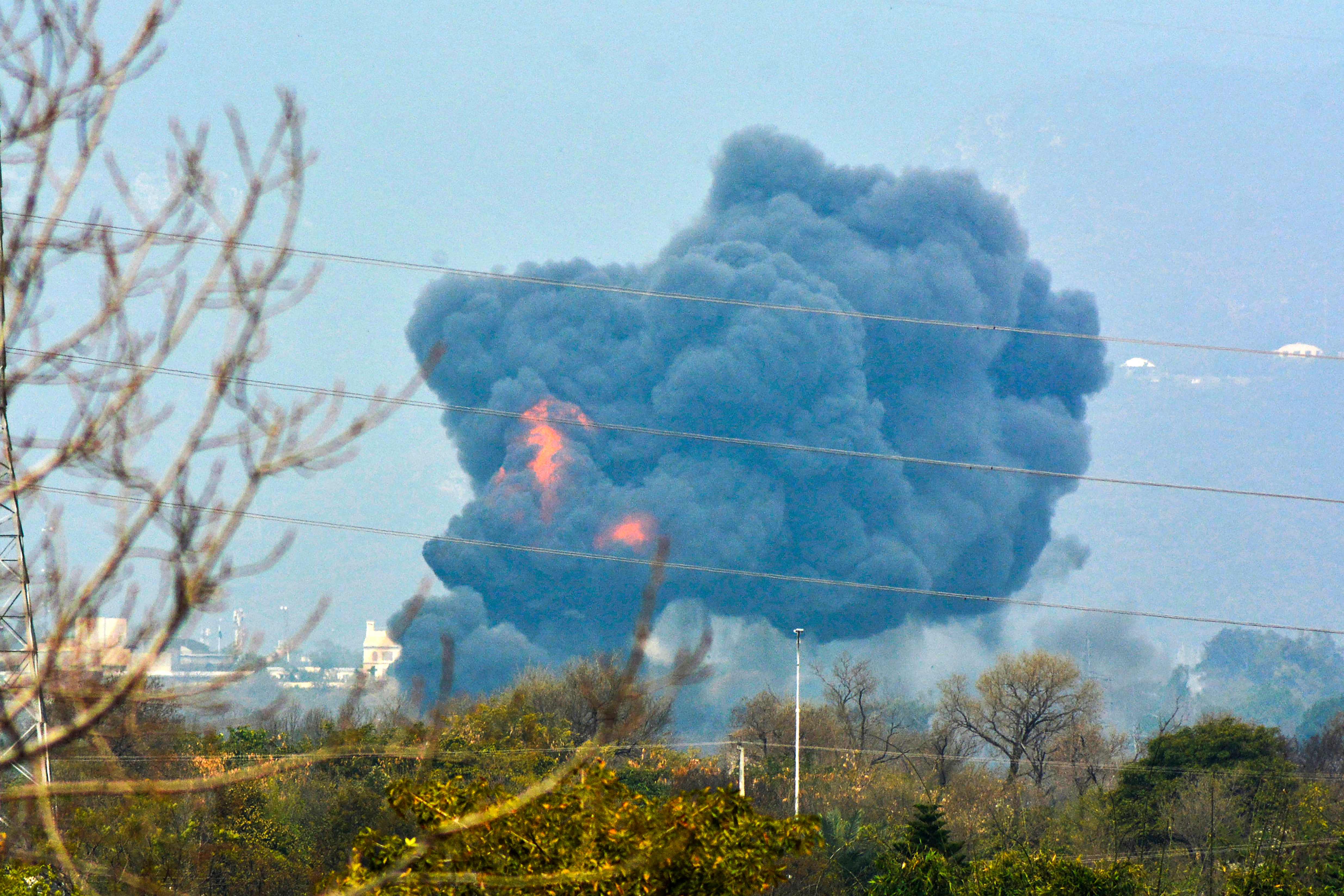 TOPSHOT - A plume of smoke and fire are seen coming from an area after a Pakistani F-16 crashed during a rehearsal ahead of Pakistan Day military parade in Islamabad on March 11, 2020. - A Pakistani F-16 fighter jet crashed in Islamabad on March 11 in an apparent accident during a rehearsal for an upcoming military parade in the capital, officials said. (Photo by STR / AFP)