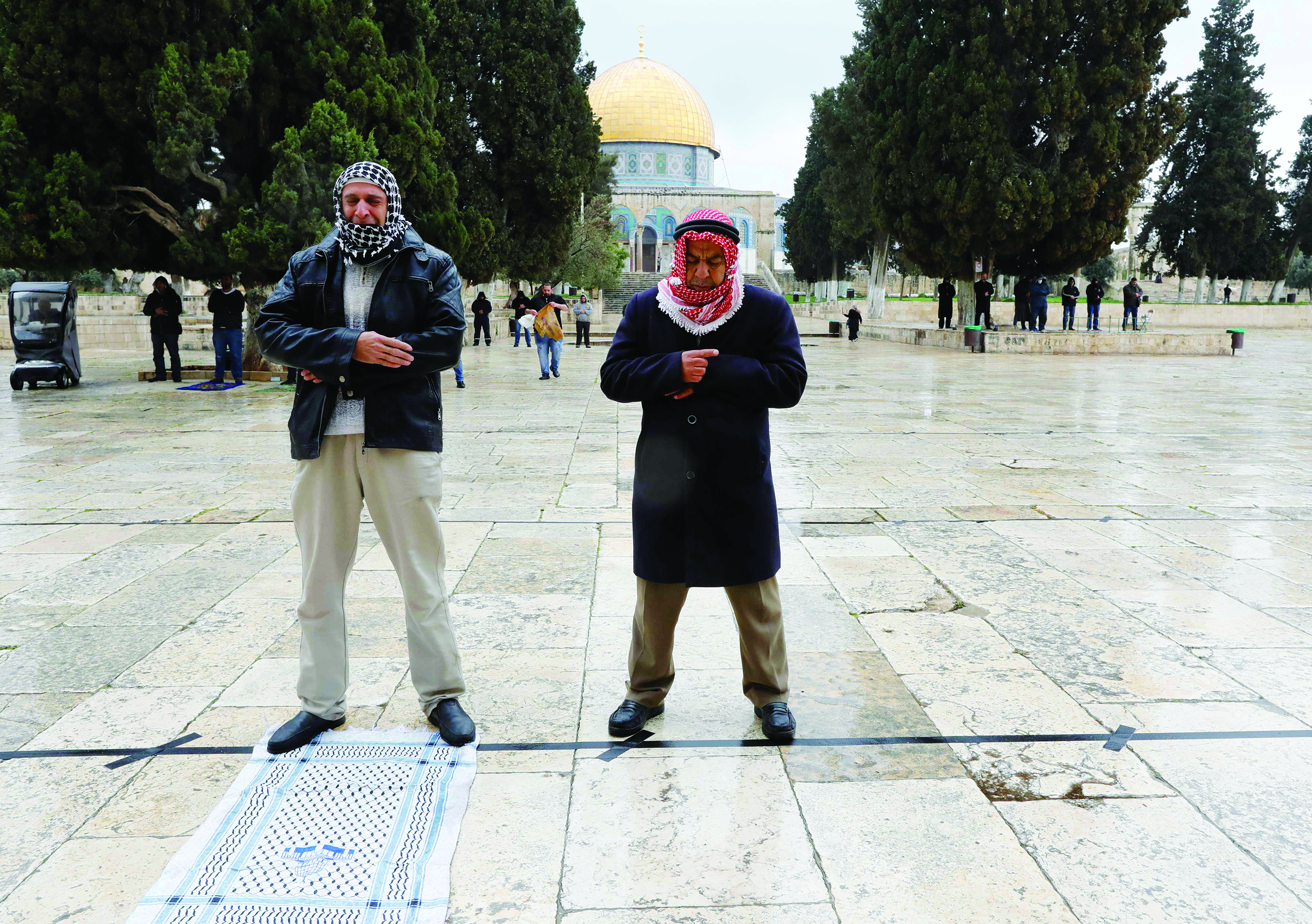 Palestinians perform their Friday prayers in the almost deserted Al-Aqsa mosque compound in the Old City of Jerusalem, after clerics took protective measures and ordered the mosques shut in a bid to stem the spread of the novel coronavirus, on March 20, 2020. - Israel has 433 confirmed cases of COVID-19, with another 44 in the occupied Palestinian territories and tens of thousands in self-isolation. (Photo by AHMAD GHARABLI / AFP)