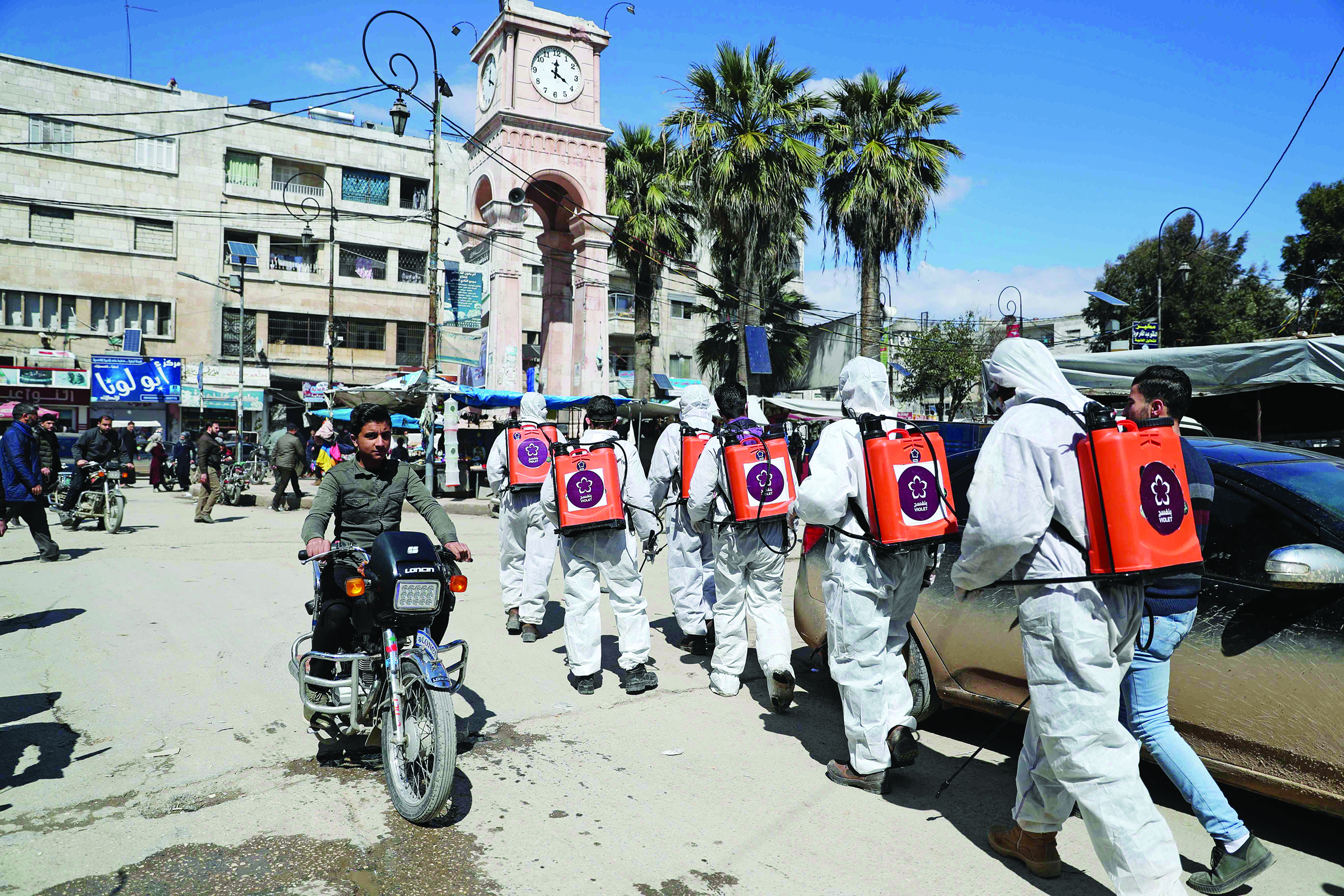 TOPSHOT - Members of the Syrian Violet NGO disinfect the streets of Syria's northwestern Idlib city on March 21, 2020 as a preventive measure against the spread of the coronavirus COVID-19. (Photo by Omar HAJ KADOUR / AFP)