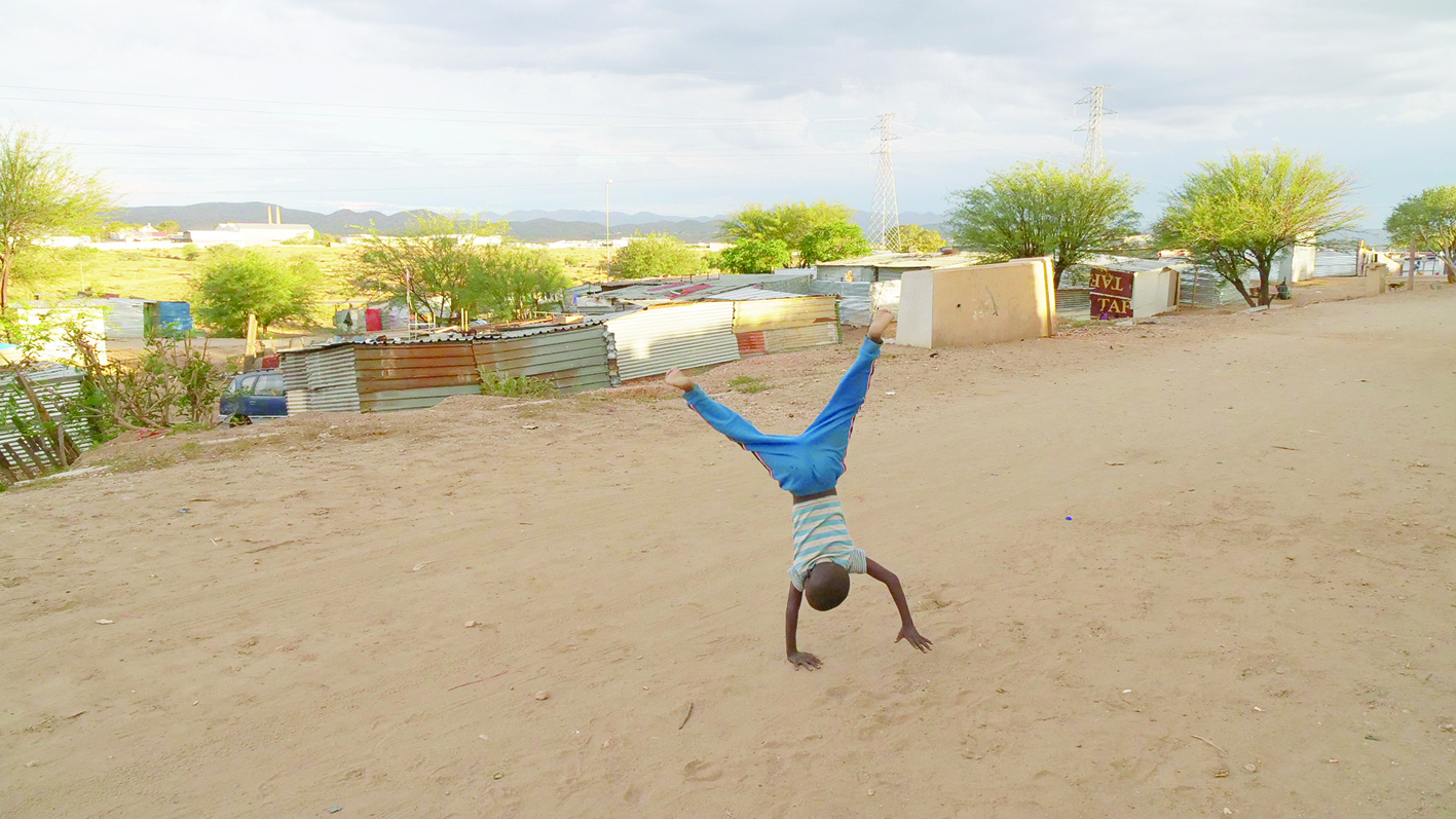A young boy does a cartwheel on a dirt road on the Okuryangava settlement in Windhoek, Namibia, 5 February 2020. Thomson Reuters Foundation/Kim Harrisberg