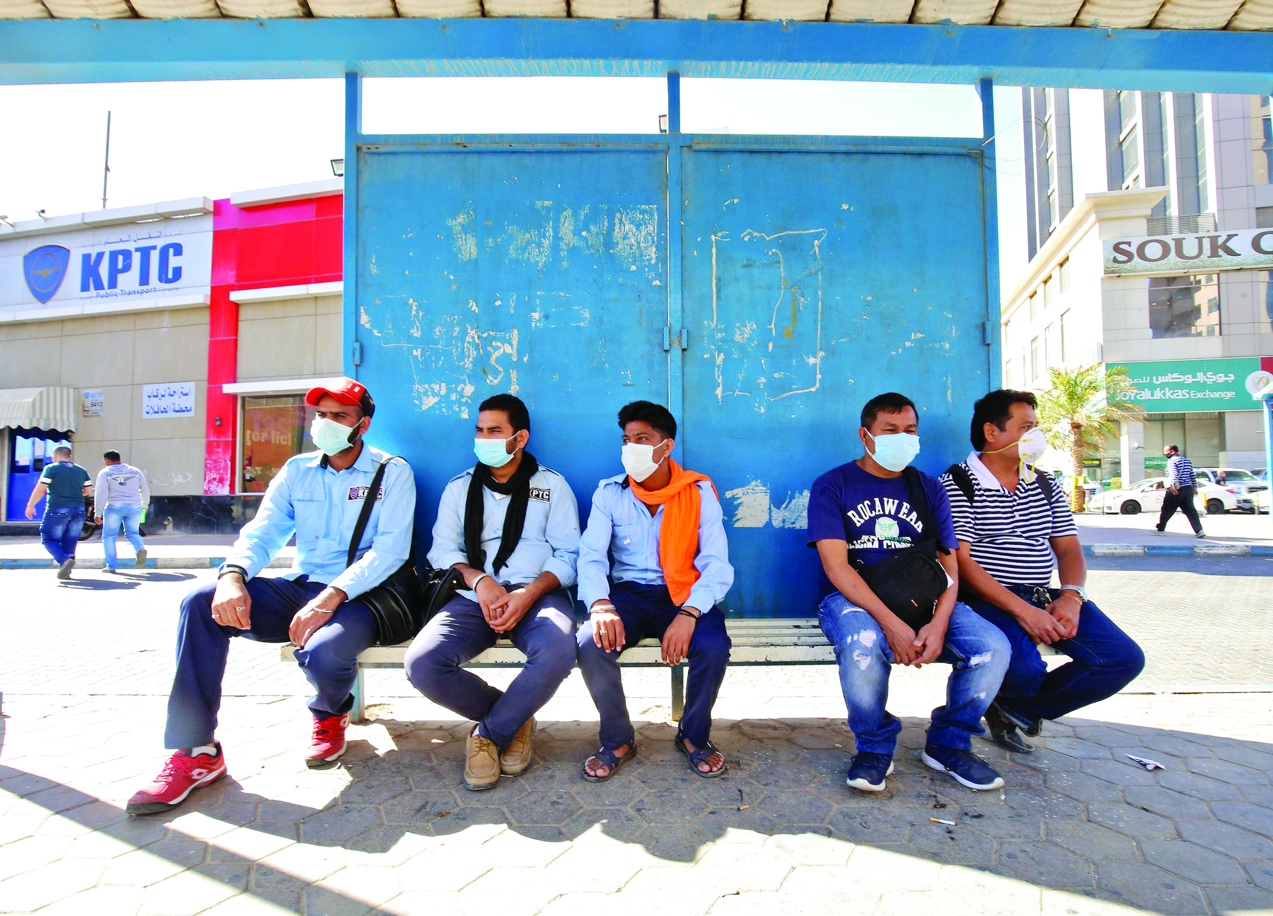 People wearing protective masks wait at a bus station in Kuwait City on March 2, 2020, amid a global outbreak of the novel Coronavirus. (Photo by YASSER AL-ZAYYAT / AFP)