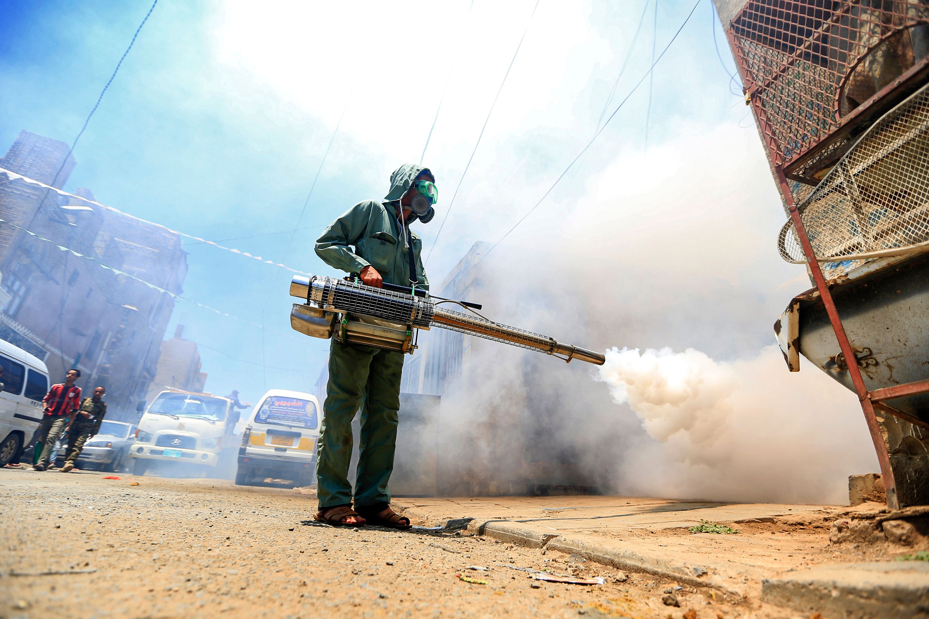 TOPSHOT - A government worker that is part of a combined taskforce tackling COVID-19 coronavirus fumigates a neighbourhood as part of safety precautions, in Yemen's capital Sanaa on March 23, 2020. (Photo by Mohammed HUWAIS / AFP)
