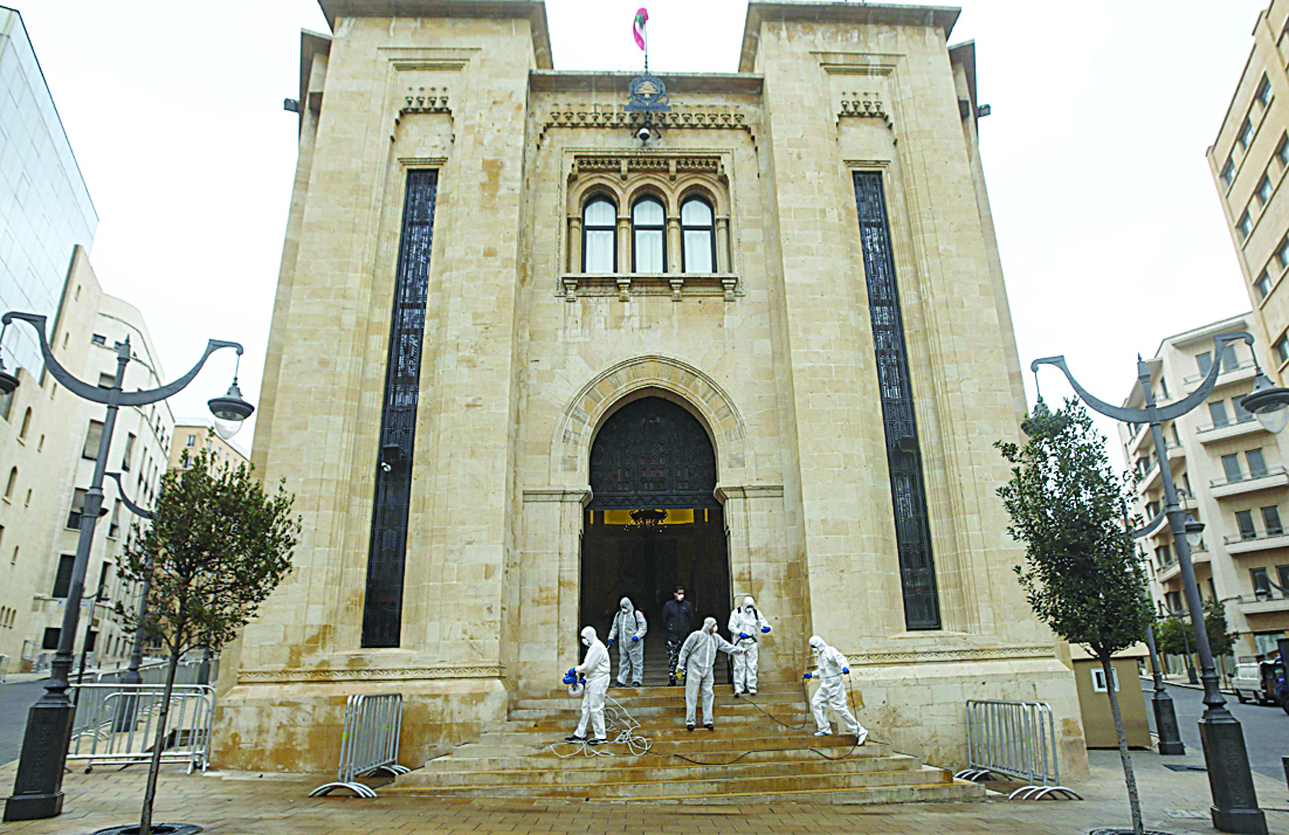 Sanitary workers disinfect the entrance of the Lebanese Parliament in central Beirut on March 10, 2020 amid the spread of coronavirus in the country. (Photo by ANWAR AMRO / AFP)