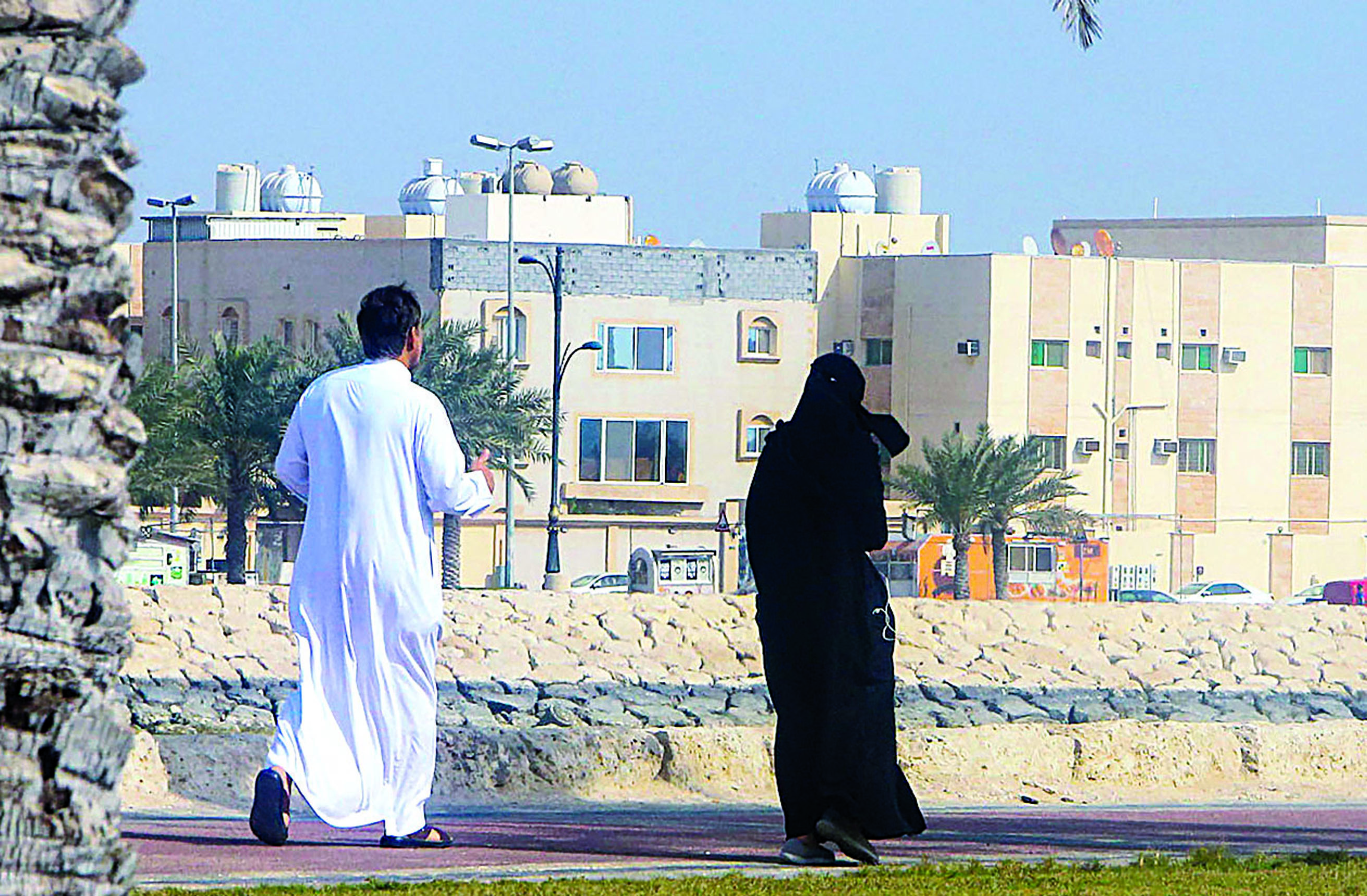 A couple takes a stroll on a sidewalk in Qatif city in Saudi Arabia's Eastern Province, some 400Km from the capital Riyadh, on March 9, 2020. (Photo by STR / AFP)